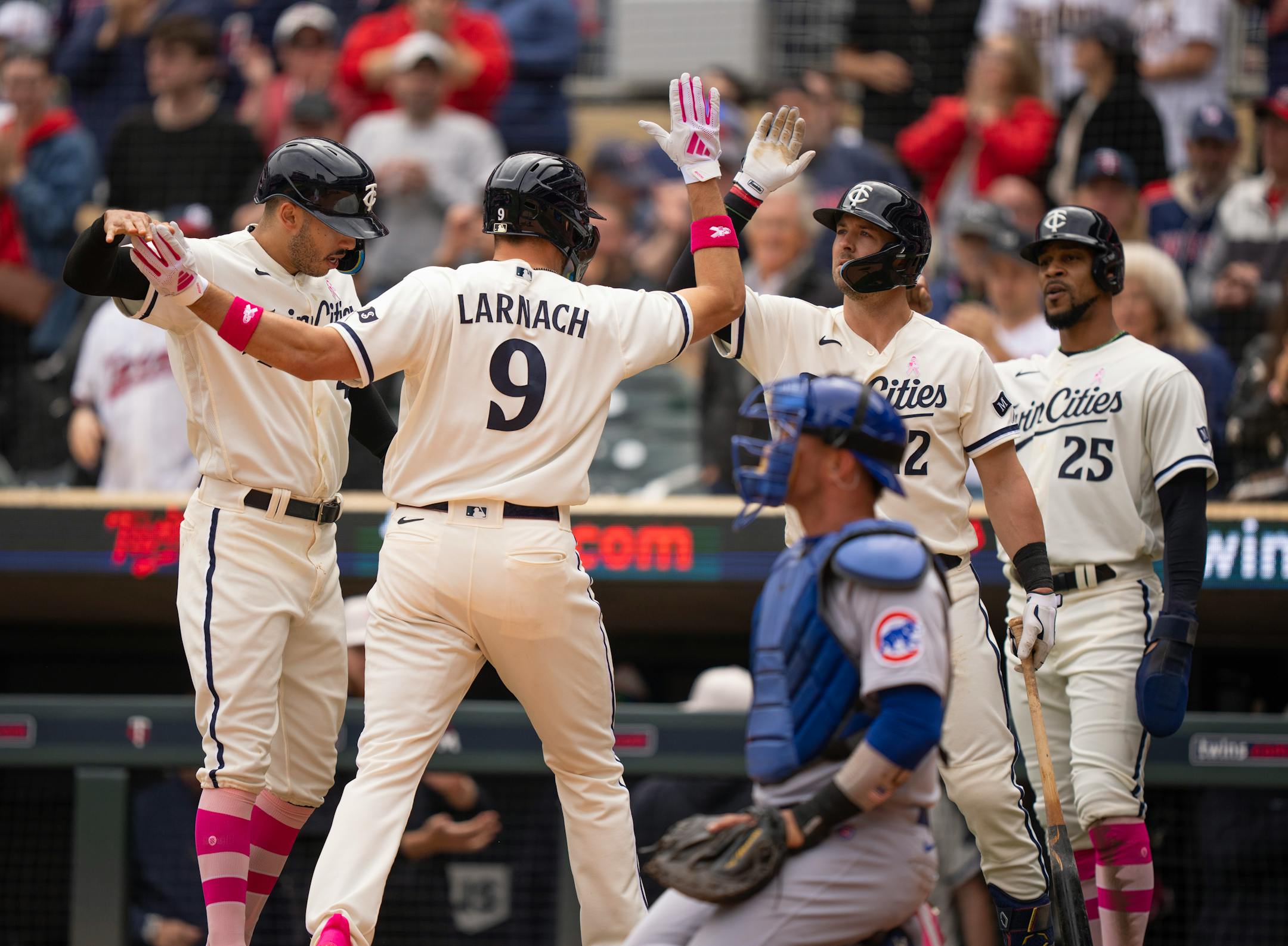 Minnesota Twins right fielder Trevor Larnach (9) was congratulated by shortstop Carlos Correa (4) and third baseman Kyle Farmer (12), with DH Byron Buxton (25) after his three run homer in the third inning.