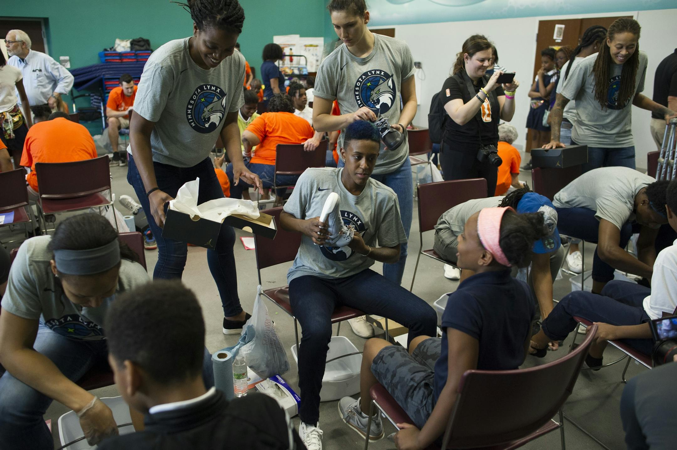 Members of the WNBA Champion Minnesota Lynx wash the feet of students and put on new Nike Jordan shoes at Payne Elementary School in Washington, Wednesday, June 6, 2018. Payne Elementary has the highest homeless student population in the district.
