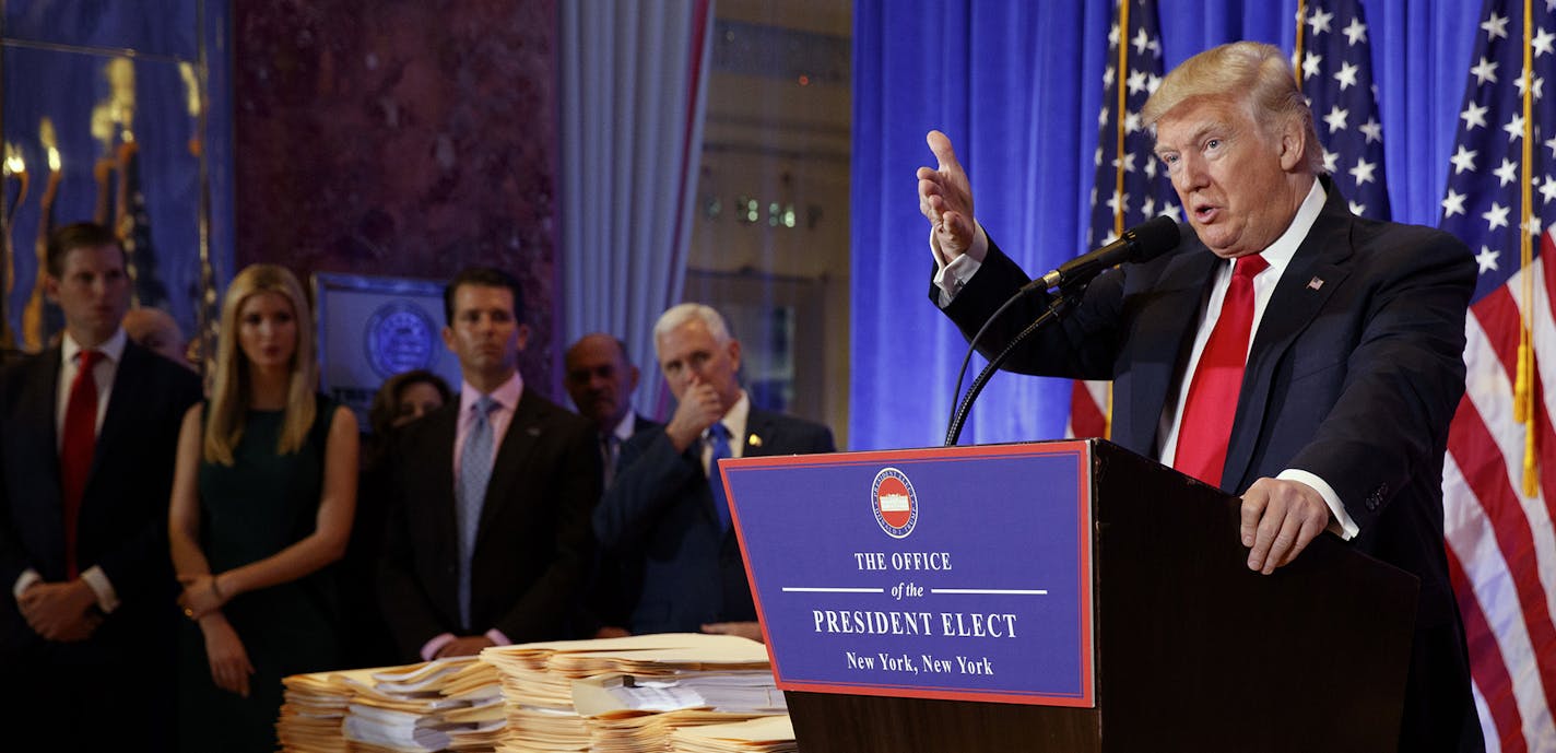 President-elect Donald Trump , accompanied by family members and Vice President-elect Mike Pence, speaks during a news conference in the lobby of Trump Tower in New York, Wednesday, Jan. 11, 2017. (AP Photo/Evan Vucci) ORG XMIT: MIN2017011114074424