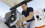 In this Thursday, Sept. 17, 2015 file photo, Darshan Brahmbhatt, plugs a charger into his electric vehicle at the Sacramento Municipal Utility Distric