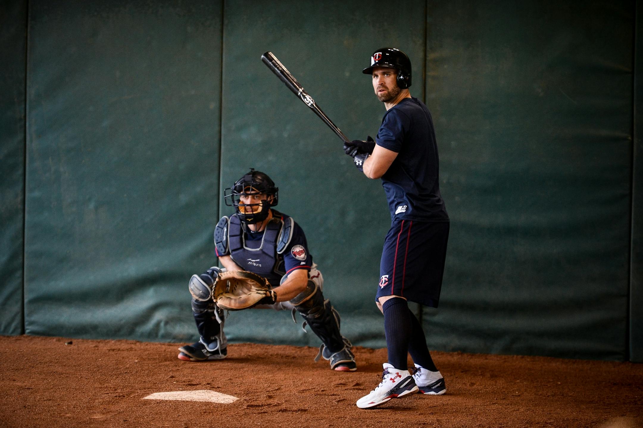 Minnesota Twins second baseman Brian Dozier (2) practiced tracking pitches as minor league catcher AJ Murray caught pitches in the bullpen Wednesday.