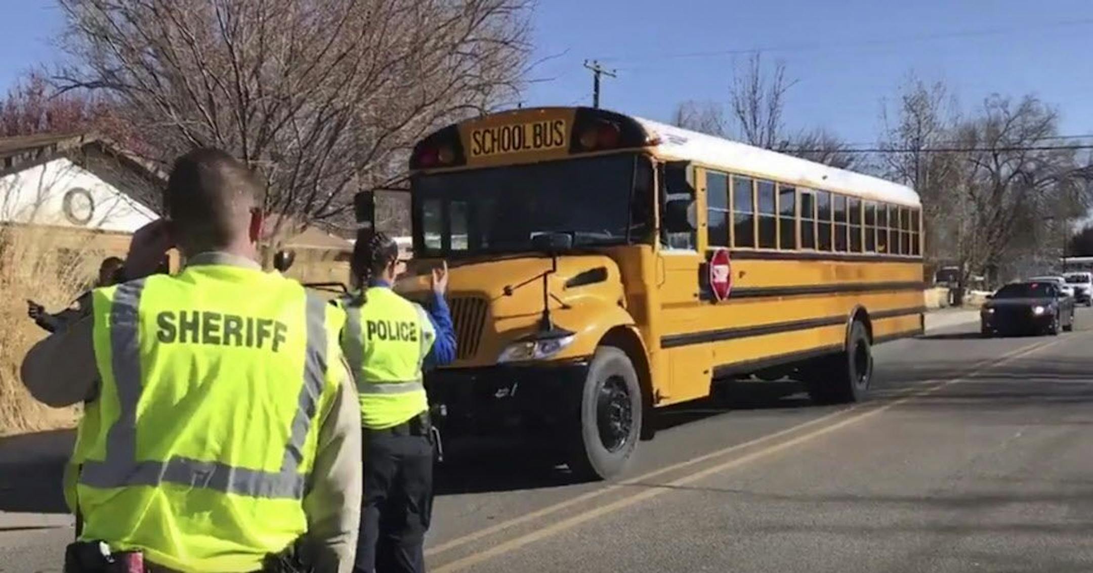 Police escort buses moving students and faculty from Aztec High School after a shooting Thursday, Dec. 7, 2017, in Aztec, N.M.