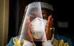 Nurse manager Nkeiru Adoga, RN, adjusted her N95 mask while putting on PPE to visit a COVID-19 patient in a step down unit at Regions Hospital in St. 