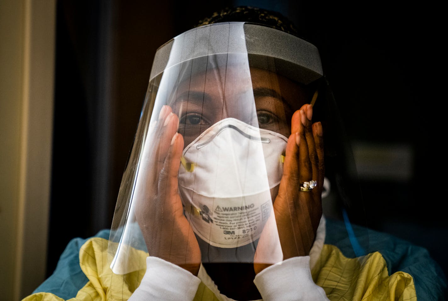 Nurse manager Nkeiru Adoga, RN, adjusted her N95 mask while putting on PPE to visit a COVID-19 patient in a step down unit at Regions Hospital in St. Paul. ] LEILA NAVIDI • leila.navidi@startribune.com