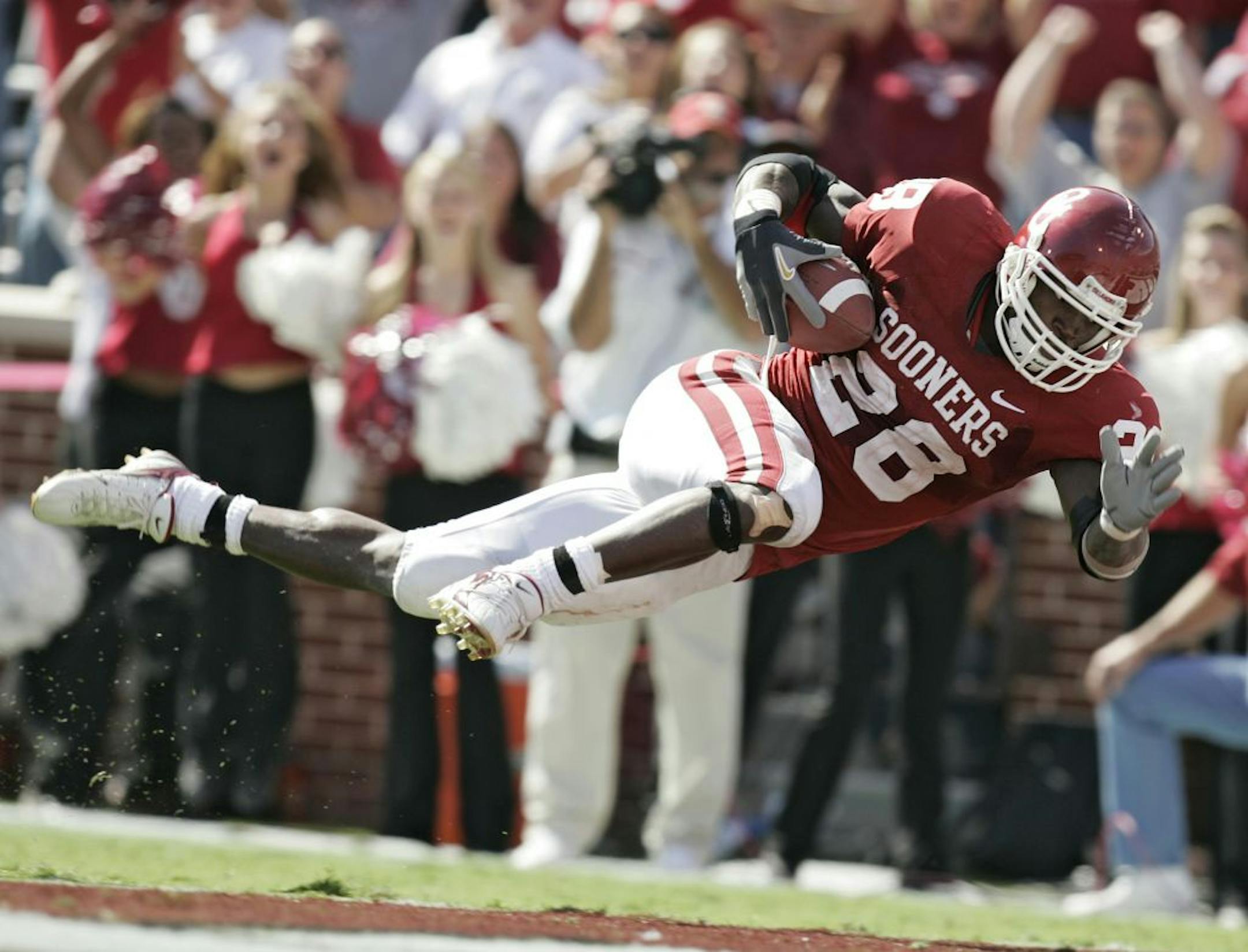 Oklahoma's Adrian Peterson dives into the end zone to score a touchdown on a 53-yard run in the fourth quarter against Iowa State in a football game Saturday, Oct. 14, 2006, in Norman, Okla. Peterson broke his collarbone on the play.