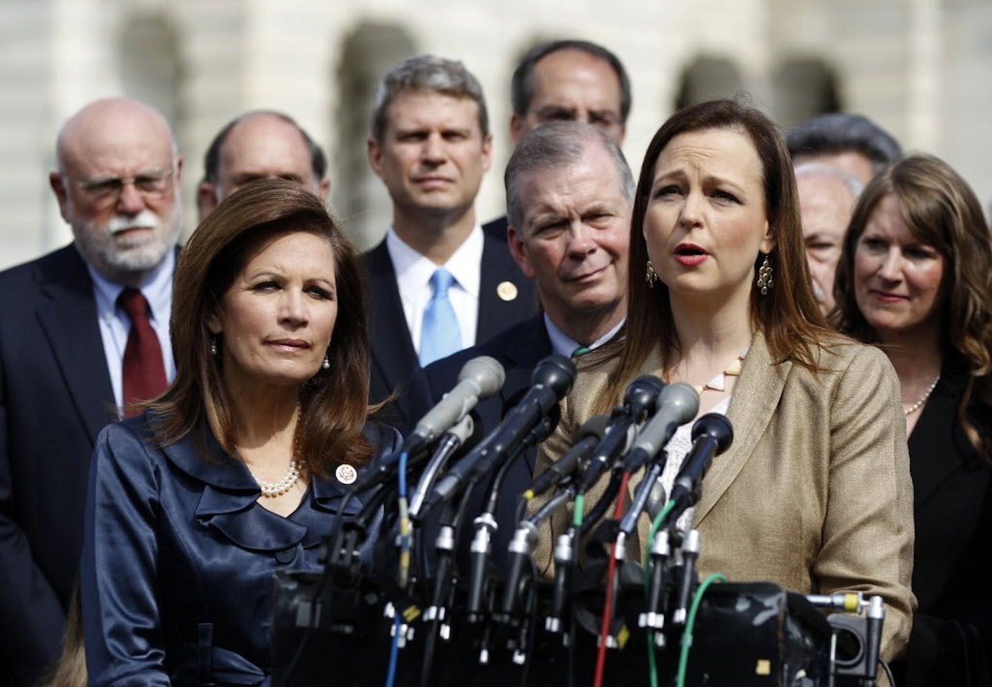 FILE -- Then-Rep. Michele Bachmann, R-Minn., chairwoman of the Tea Party Caucus, listens at left, as Jenny Beth Martin, co-founder and national coordinator of the Tea Party Patriots, speaks during a news conference with Tea Party leaders about the IRS targeting Tea Party groups, Thursday, May 16, 2013, on Capitol Hill in Washington.