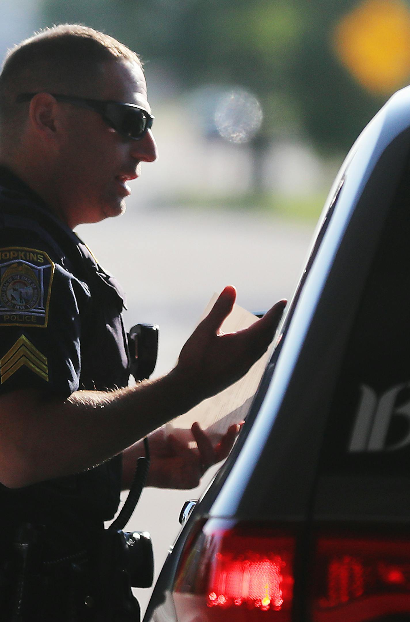 Hopkins police officer Sgt. Mike Glassberg was out patrolling Hopkins roads looking for violators on the first day of the new hands free law Thursday, Aug. 1, 2019, in Hopkins, MN. Here, Sgt. Glassberg issued a ticket to a driver that had been holding a cell phone near Highway 169 and Excelsior Blvd.]
DAVID JOLES &#x2022; david.joles@startribune.com The state's new hands free law kick in Thursday and drivers who hold a phone or other electronic device in their hands should not expect to receive