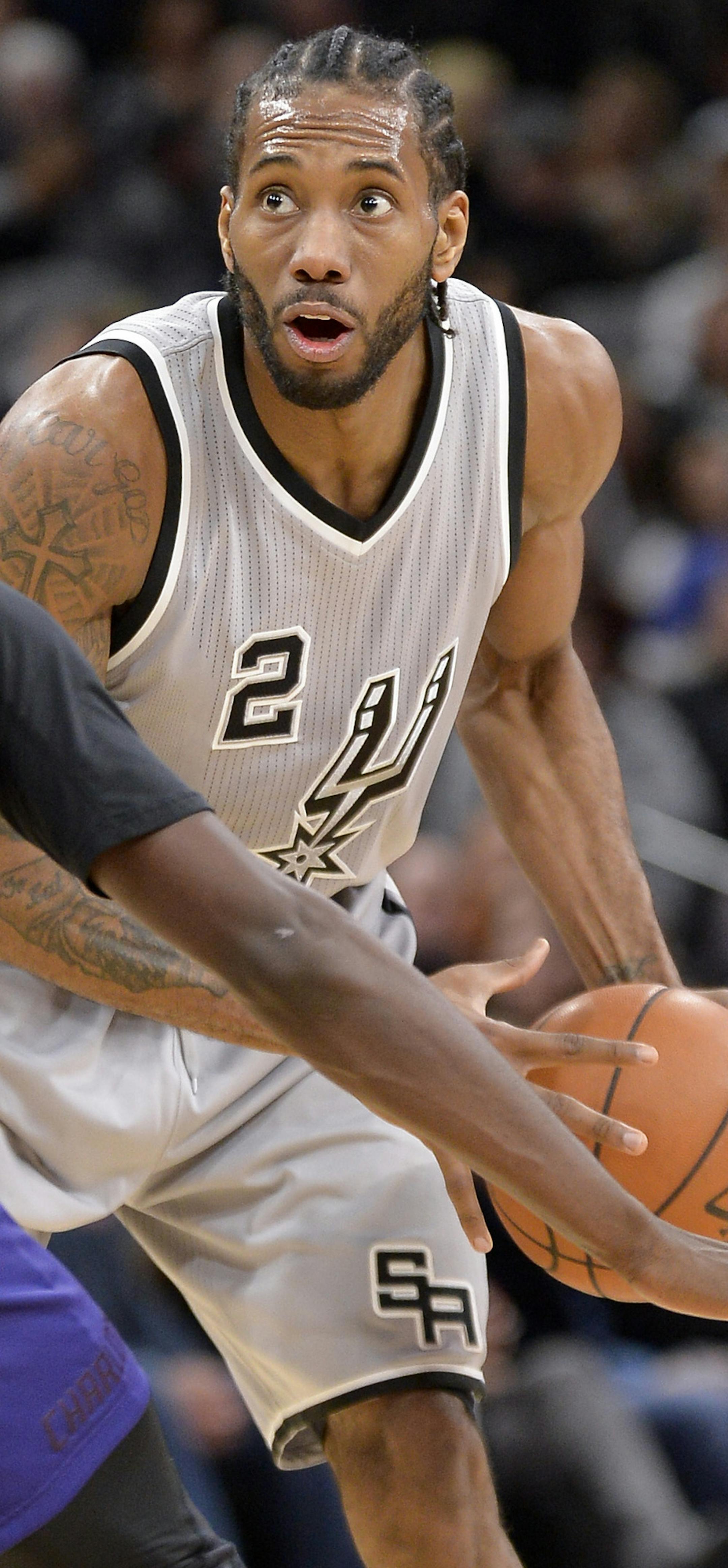 San Antonio Spurs forward Kawhi Leonard (2) looks to pass around Charlotte Hornets forward Michael Kidd-Gilchrist during the second half of an NBA basketball game, Saturday, Jan. 7, 2017, in San Antonio. San Antonio won 102-85. (AP Photo/Darren Abate)