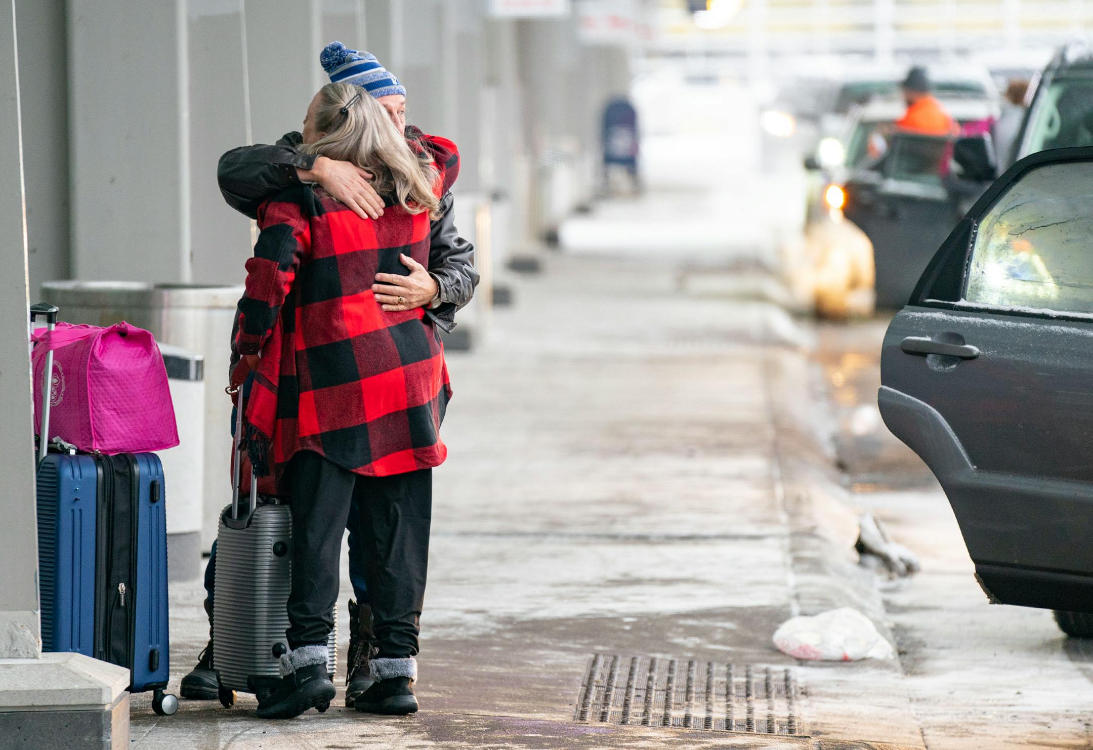 A traveler is embraced before entering Terminal 1 of Minneapolis-Saint Paul International Airport.