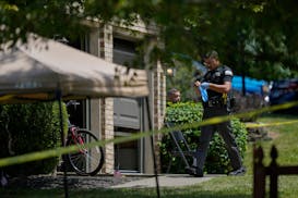 A member of the Florence, Ky., Police Department puts on protective gloves at a home where a shooting took place, Saturday, July 6, 2024, in Florence,