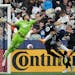 Vancouver's Ranko Veselinovic, second right, heads the ball wide of the goal behind Minnesota United goalkeeper Dayne St. Clair during the first half 