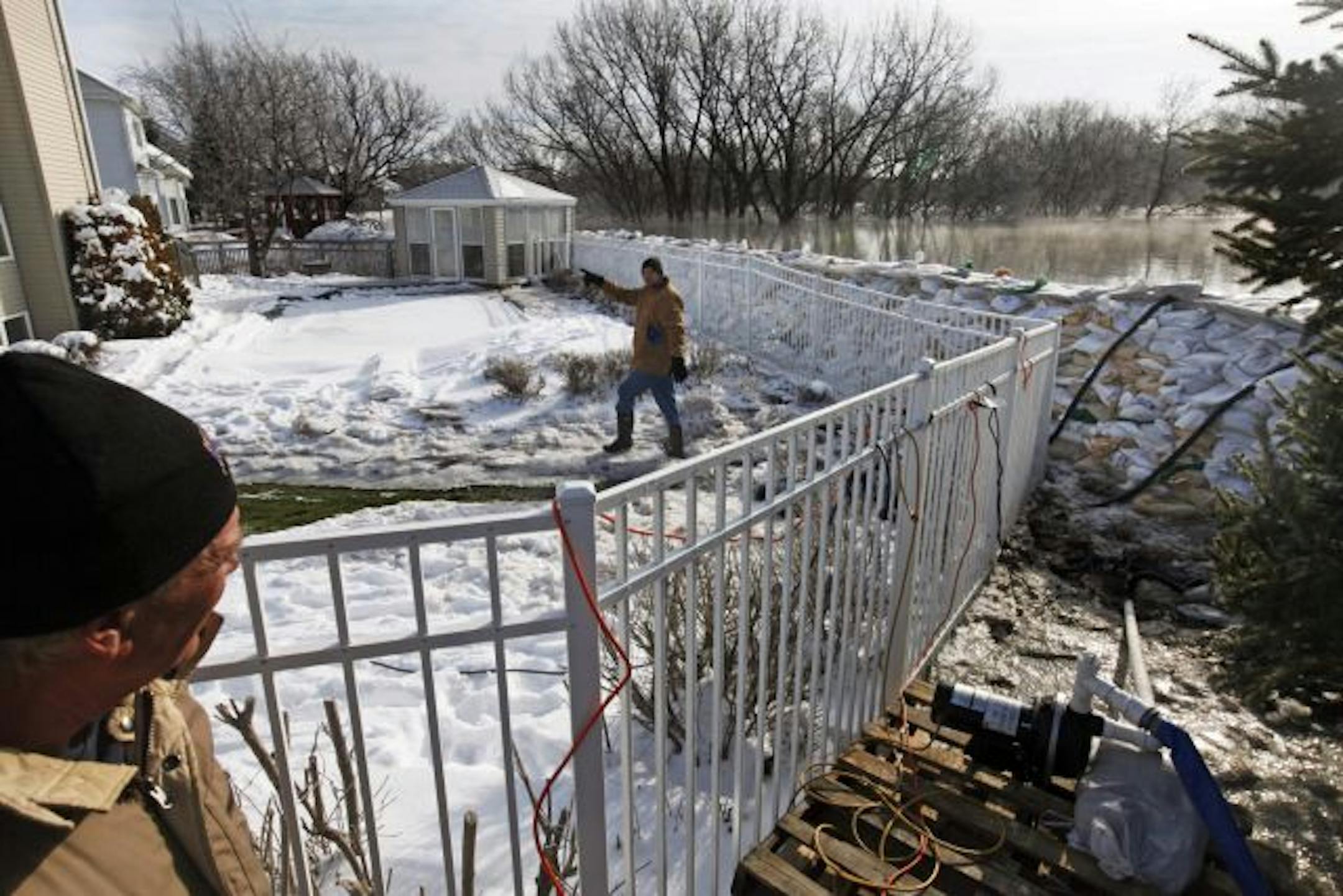 On Hackberry Drrive in south Fargo along the Red River, Larry Strande and his son Tom Miller of Mound, Minnesota check on the sump pumps that are keeping the home dry. Strande's home is on the outside of the secondary dike in the neighborhood.