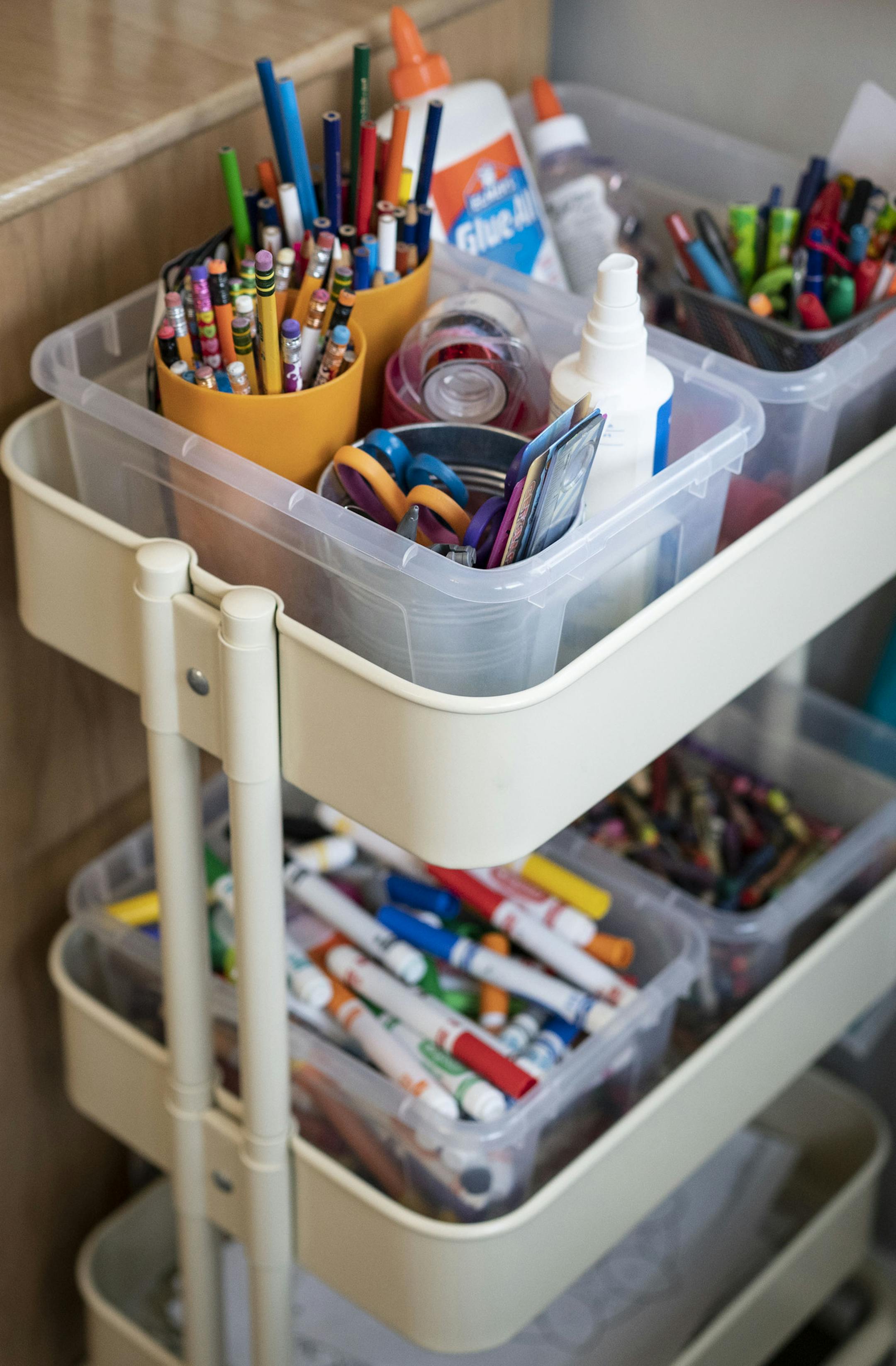 An "art cart" on wheels holds school and craft supplies.