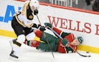 Minnesota Wild center Mikael Granlund (64) fell to the ice while chasing the puck while being challenged by Boston Bruins right wing Tyler Randell (64