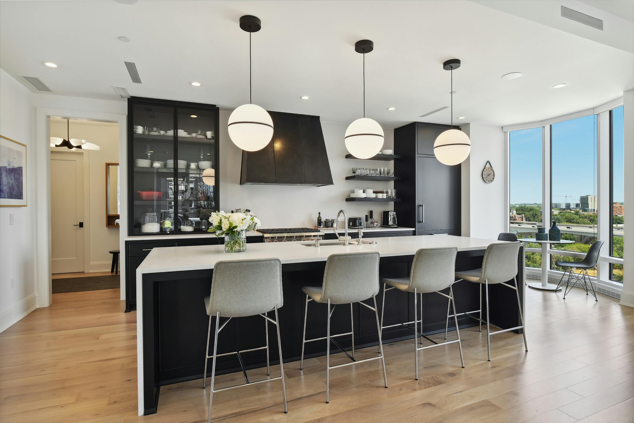 The kitchen, with modern black accents, upper glass pantries, top-end stainless steel appliances and quartz countertops.&nbsp;