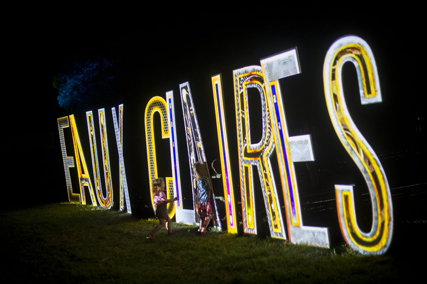 Children played by the illuminated Eaux Claires sign Saturday night during Bon Iver's set. ] Aaron Lavinsky &#x2022; aaron.lavinsky@startribune.com The Eaux Claires Music & Art Festival was photographed Saturday, July 18, 2015 in Eau Claire, WI.