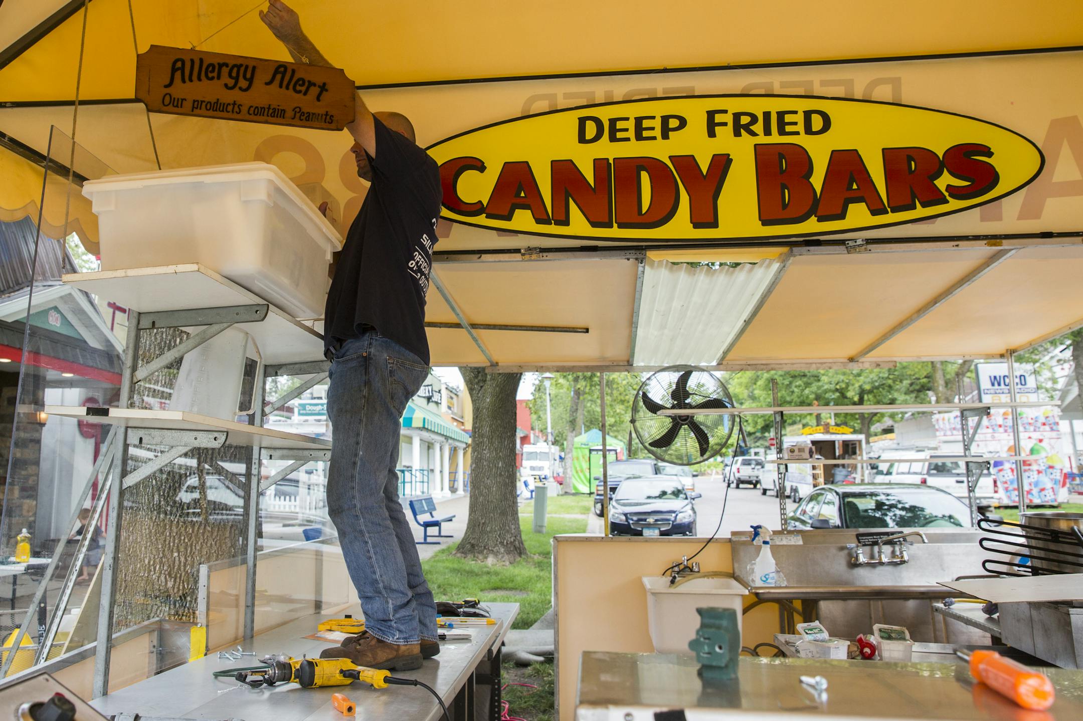 Donald Waddell of Old Style Foods based out of North Carolina sets up their Deep Fried Candy Bars food booth at the Minnesota State Fairgrounds. ] (Leila Navidi/Star Tribune) leila.navidi@startribune.com BACKGROUND INFORMATION: Rides and booths set up the week before the Minnesota State Fair in Falcon Heights on Thursday, August 18, 2016.