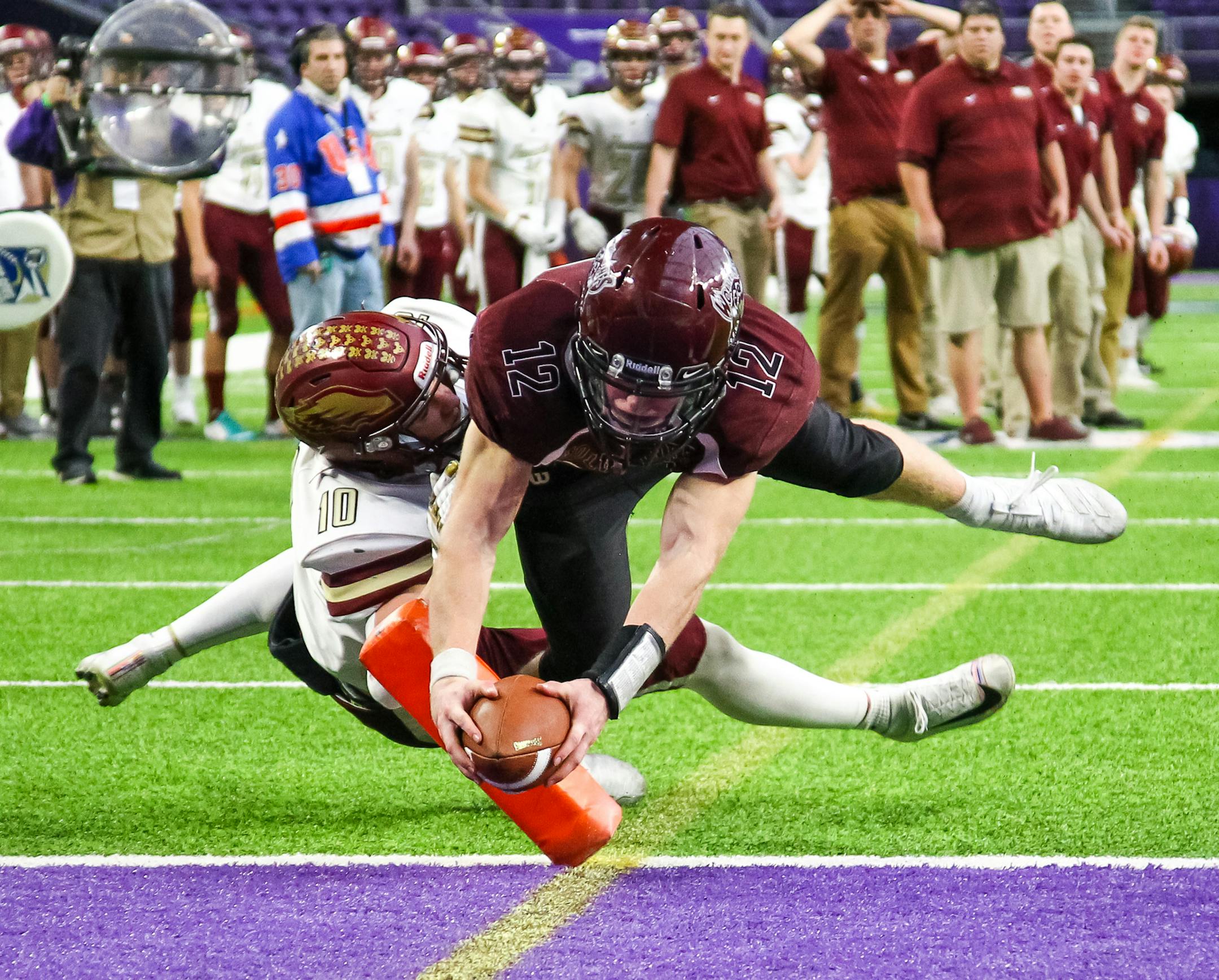 Mountain Lake Area Wolverines quarterback Abraham Stoesz (12) runs with the ball for a touchdown in the third quarter against Hancock Owls wide receiver Brandon Kellenberger (10). ] David Berding • Special to the Star Tribune Hancock played Mountain Lake Area in the Nine-Man State Tournament Championship game on Saturday, November 30, 2019 at US Bank Stadium in Minneapolis, Minnesota.