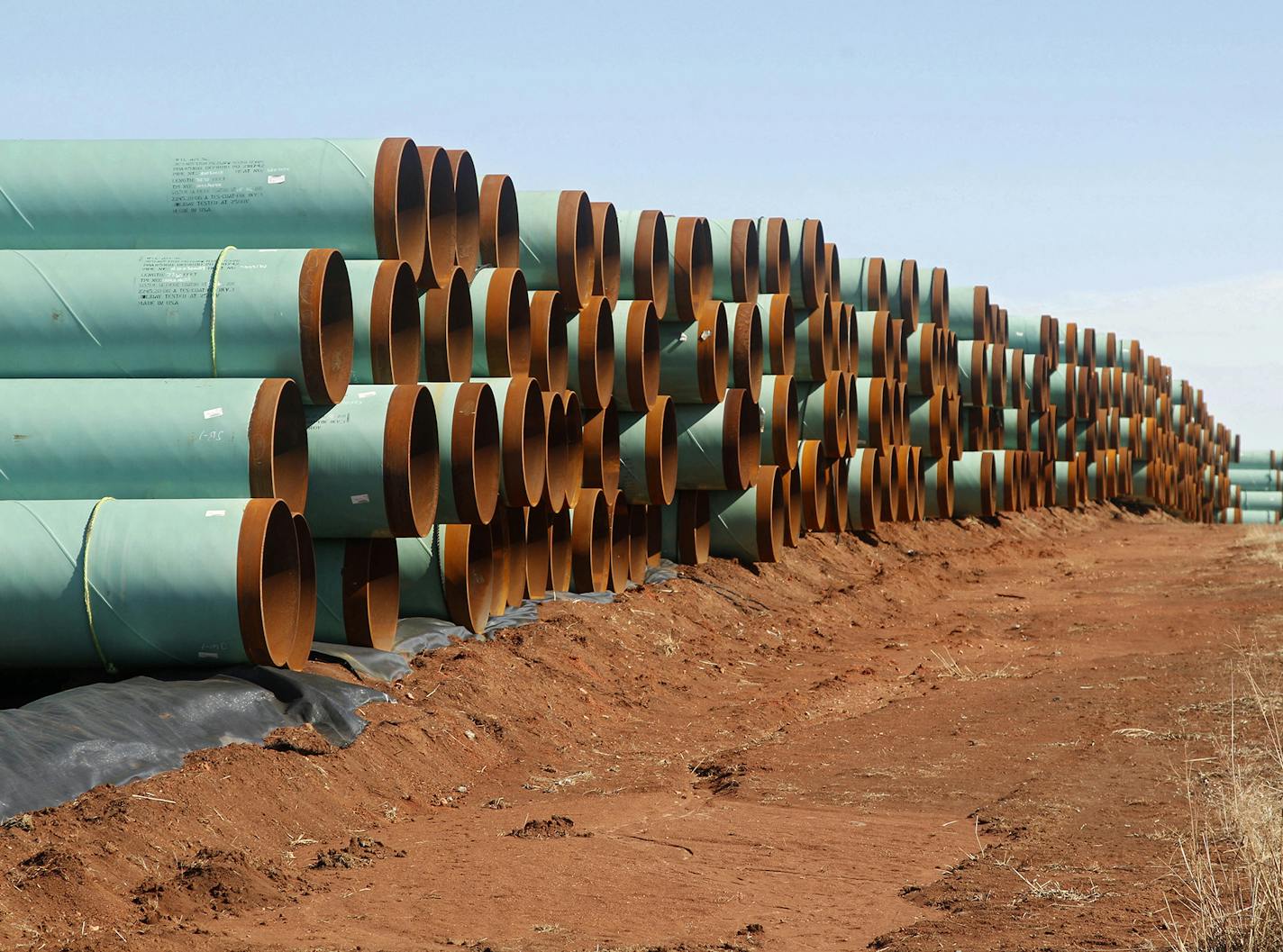 In this Feb. 1, 2012, file photo, miles of pipe ready to become part of the Keystone Pipeline are stacked in a field near Cushing, Okla.