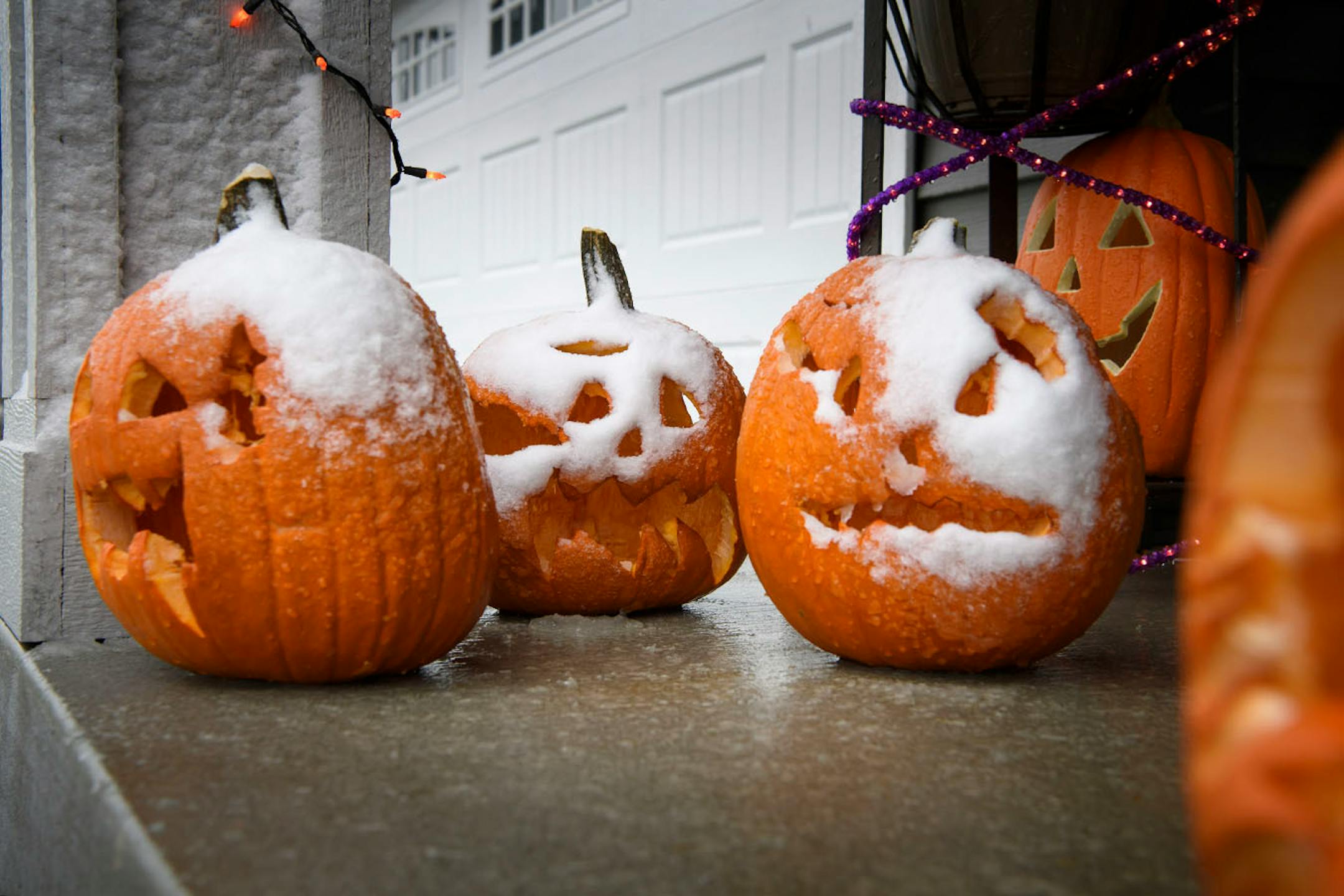 Grimacing snow-covered Jack-o-lanterns on a porch in Apple Valley Friday afternoon. These were carved by siblings Dominic, 10, Lilly, 8, and Vinny, 8 last weekend. Minnesotans got an early shot of nasty weather the Friday before Halloween.