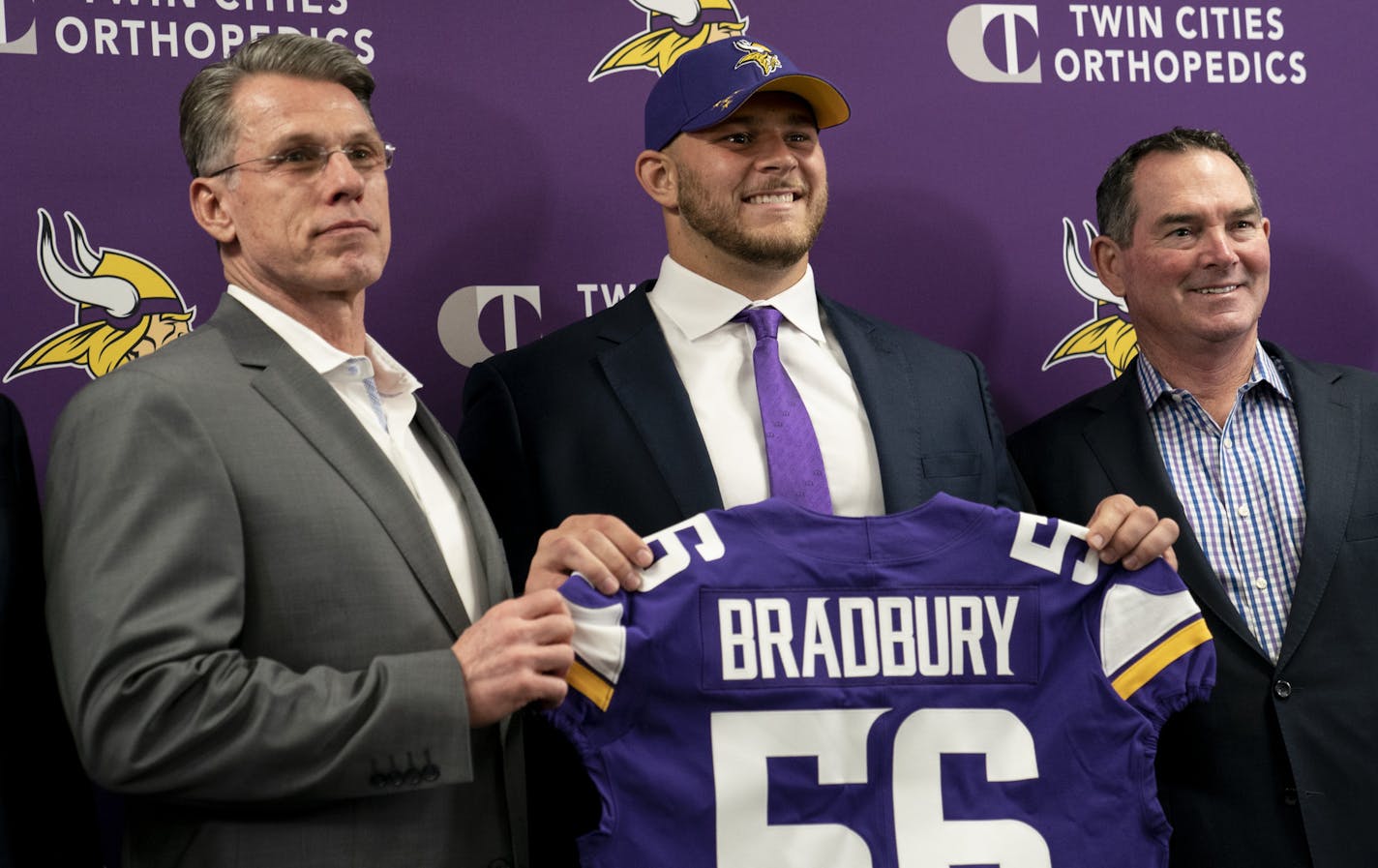 Garrett Bradbury held his jersey #56 with, from the left, general manager Rick Spielman and head coach Mike Zimmer during a press conference at the TCO Performance Center News in Eagan, Minn., on Friday, April 26, 2019. ] RENEE JONES SCHNEIDER &#xa5; renee.jones@startribune.com