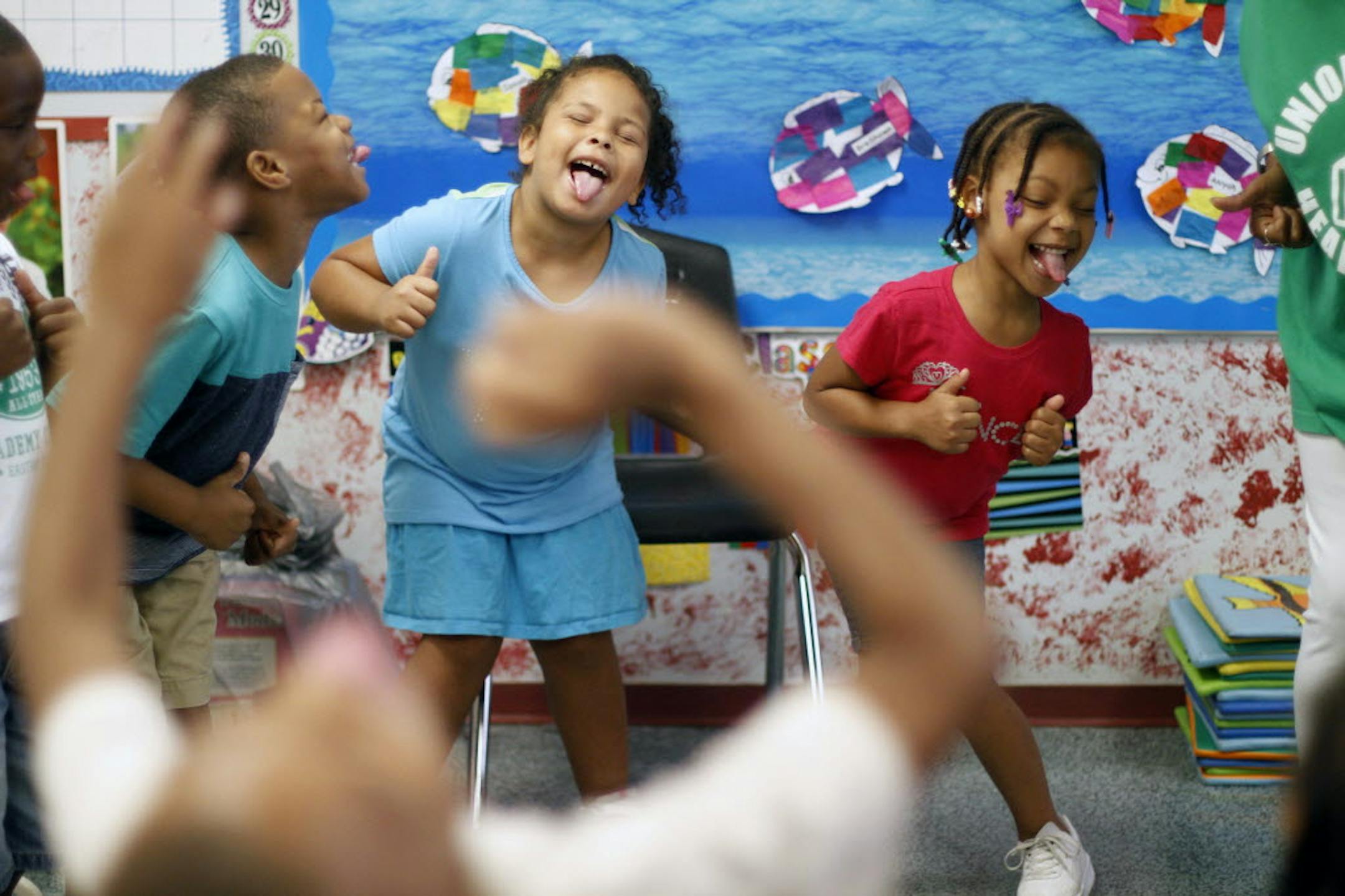 Mehki Lee, 5, left, Stephanie Ogle, 5, center, and Zaiyana Thompson, 5, do a motion break exercise with their class at Union Baptist-Harvey Johnson Head Start summer camp in Baltimore.