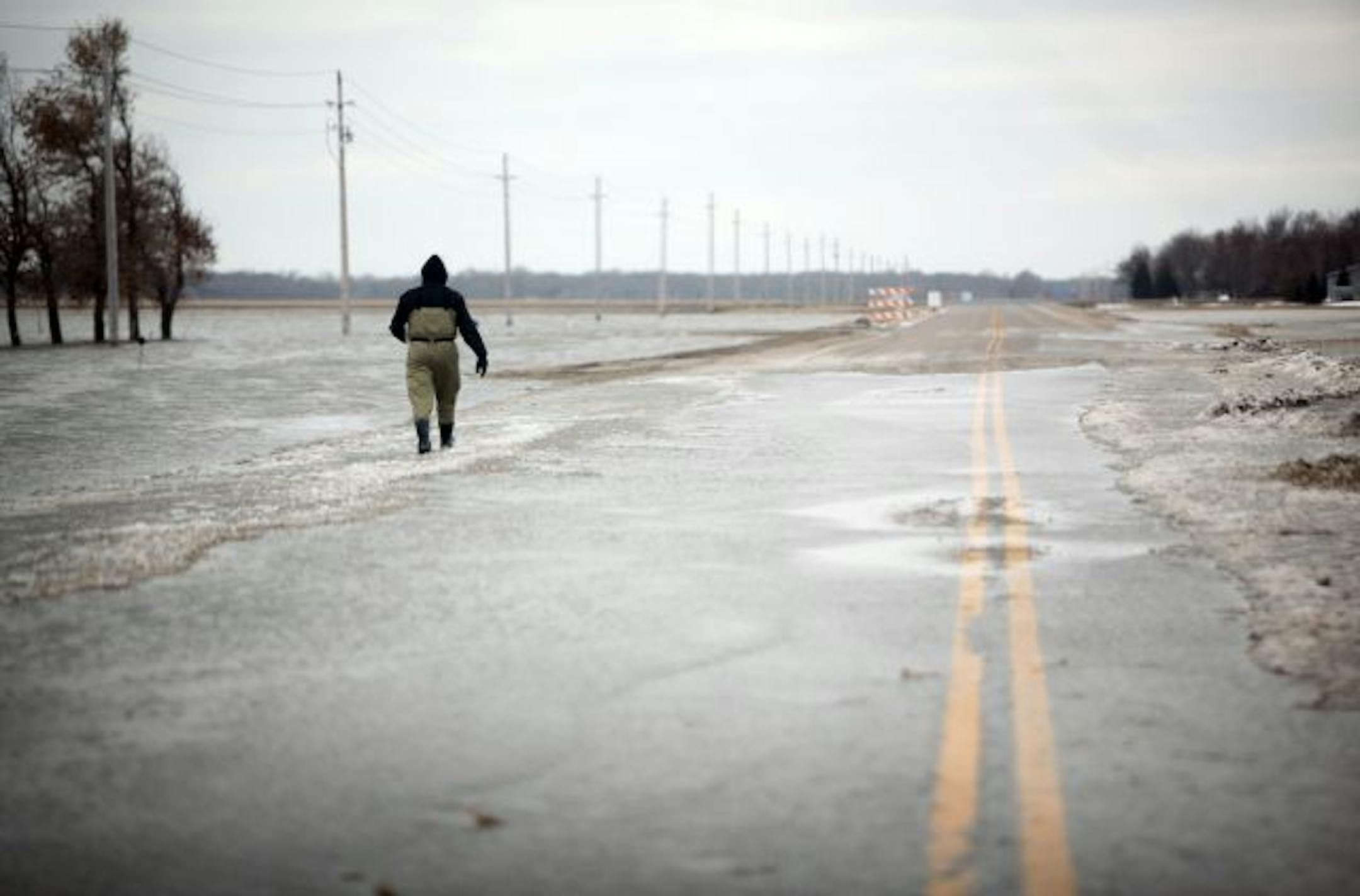 Monte Bachmann walked through water along County Road 81 south of Fargo Friday morning. County Road 81 is a main road that runs north/south through Fargo.
