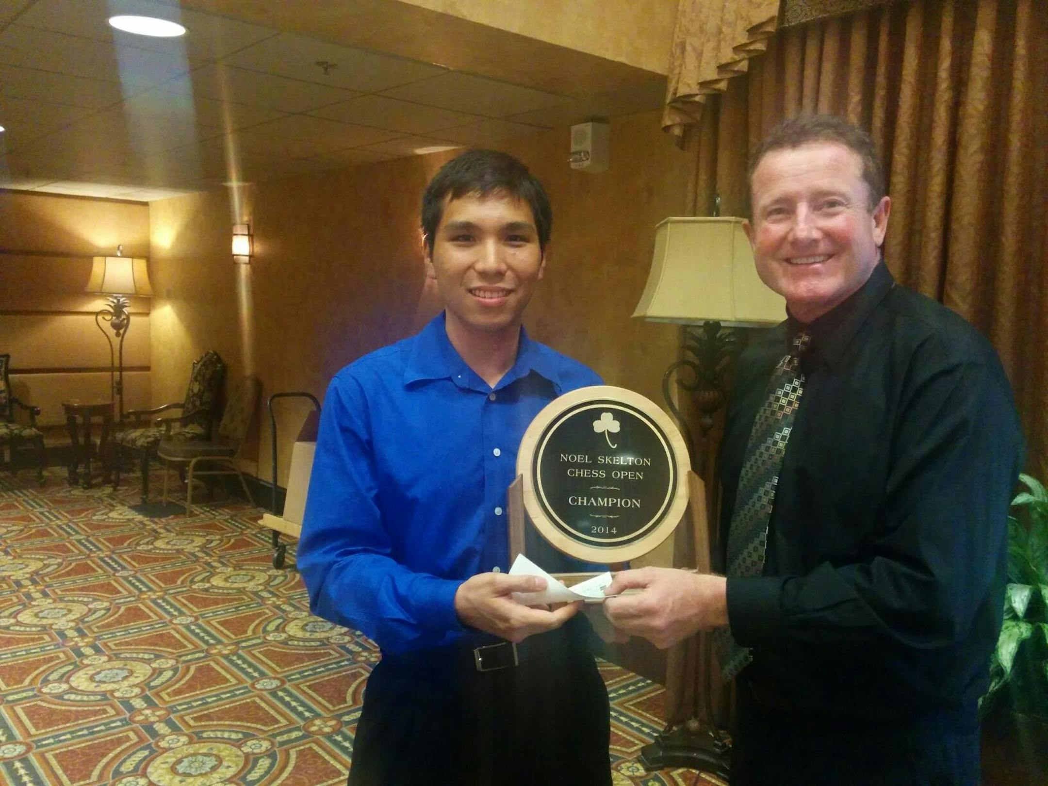 Chess Grandmaster Wesley So, left, receives the champion's trophy from Noel Skelton, sponsor of the Noel Skelton Open chess tournament held in Plymouth over the Labor Day weekend.