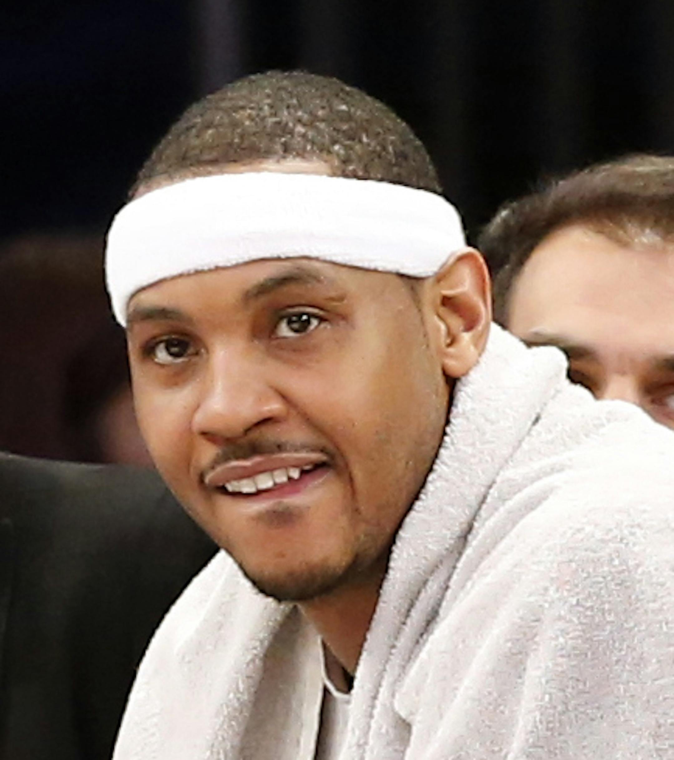 New York Knicks forward Carmelo Anthony, center, wearing a towel, watches from the bench in the second half of an NBA basketball game against the Toronto Raptors at Madison Square Garden in New York, Sunday, April 10, 2016. The Raptors defeated the Knicks 93-89. (AP Photo/Kathy Willens)