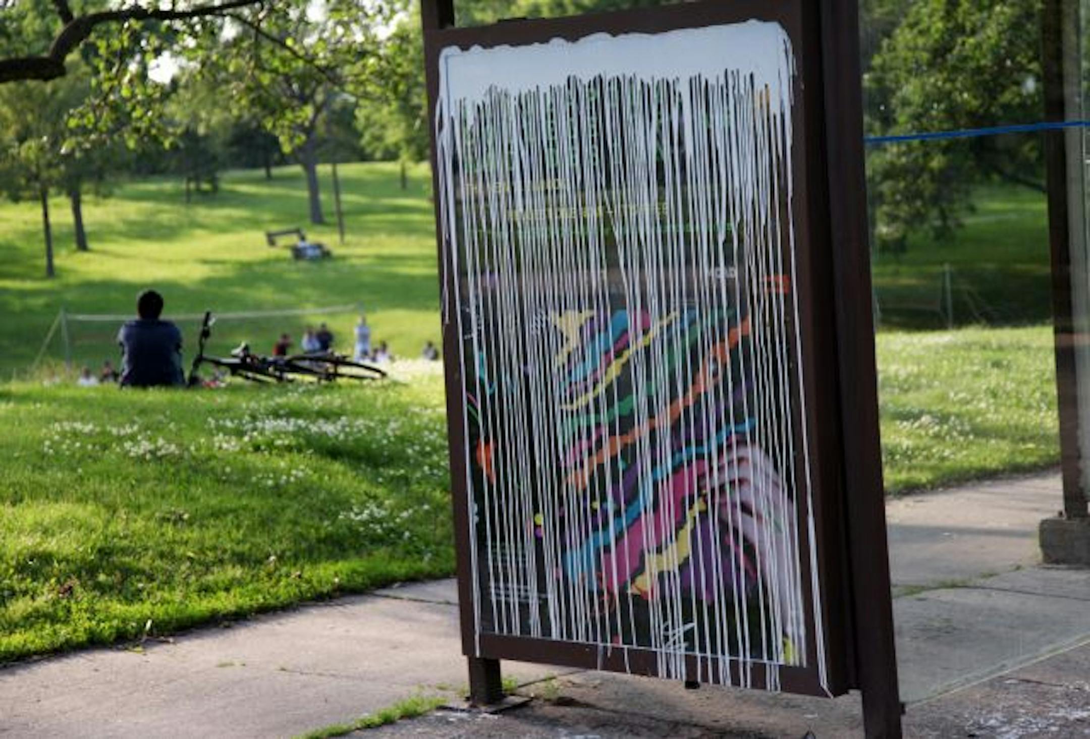 A bus stop across from the Minneapolis Institute of Arts had paint splattered on an ad, an example of what is believed to be the work of the Paint Bomber. Police records show 25 incidents since February.
