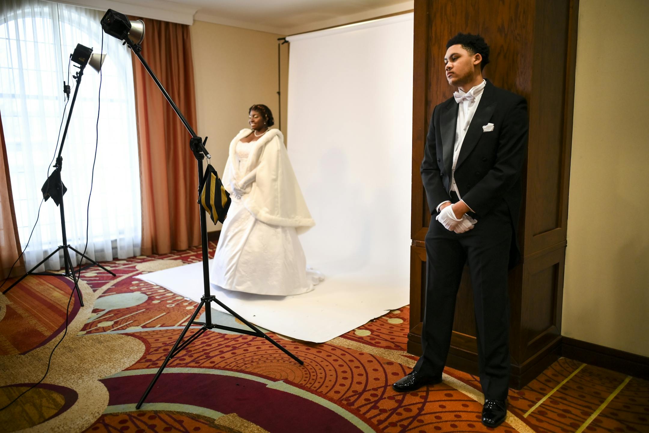 John Williams Jr., 17, a student at Cristo Rey Jesuit High School, waited for debutante Robyn Tisdale, 17, a junior at Cretin Derham Hall, as she stood for photos before Saturday's cotillion.