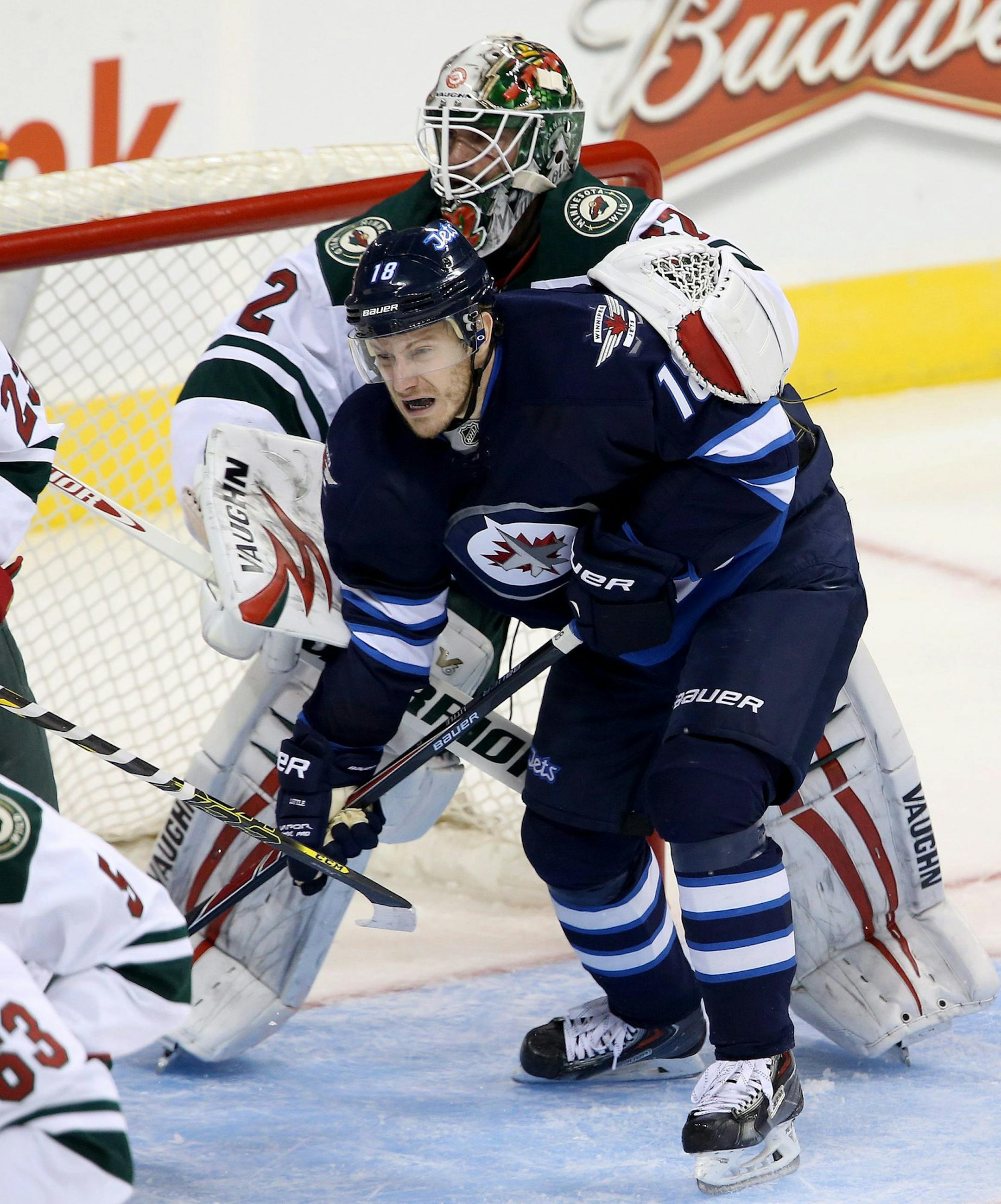 Winnipeg Jets' Bryan Little (18) is wrapped up by Minnesota Wild's goaltender Niklas Backstrom (32) during first period pre-season NHL hockey action in Winnipeg, Monday, Sept. 22, 2014. (AP Photo/The Canadian Press, Trevor Hagan)