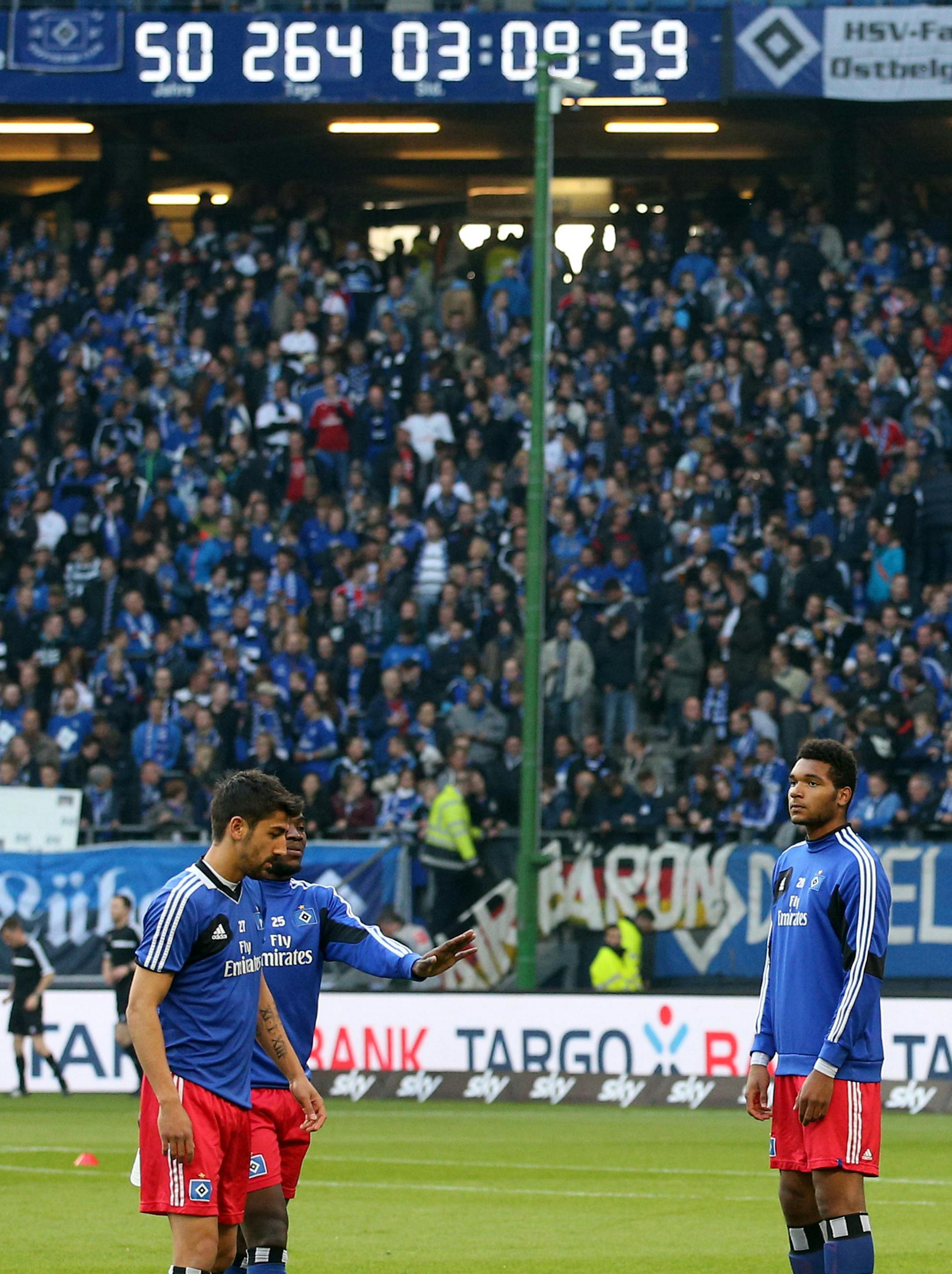 Kerem Demirbay (L), Ola John (2-L) and Jonathan Tah in front of the large clock is picutred marking the time that Hamburger SV has been part of the Bundesliga during the Relegation soccer match for the German Bundesliga between Hamburger SV and SpVgg Greuther Fuerth in Hamburg, Germany, 15 May 2014. Photo by: Christian Charisius/picture-alliance/dpa/AP Images ORG XMIT: 140516-99-01967