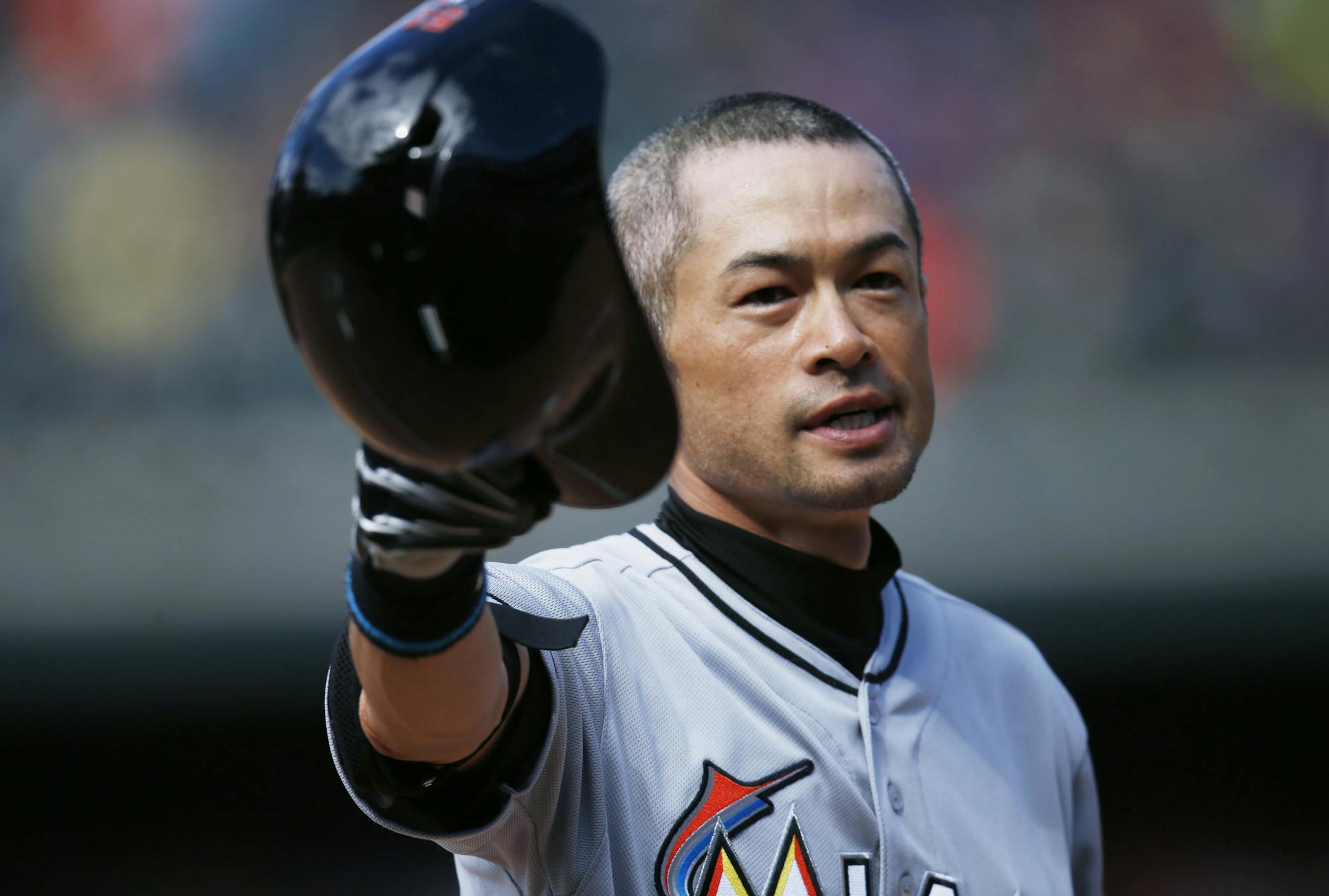 Miami Marlins' Ichiro Suzuki tips his batting helmet to the crowd as fans applaud after he hit a triple off Colorado Rockies relief pitcher Chris Rusin in the seventh inning of a baseball game, Sunday, Aug. 7, 2016 in Denver. The hit was the 3,000th in his Major League career. (AP Photo/David Zalubowski)
