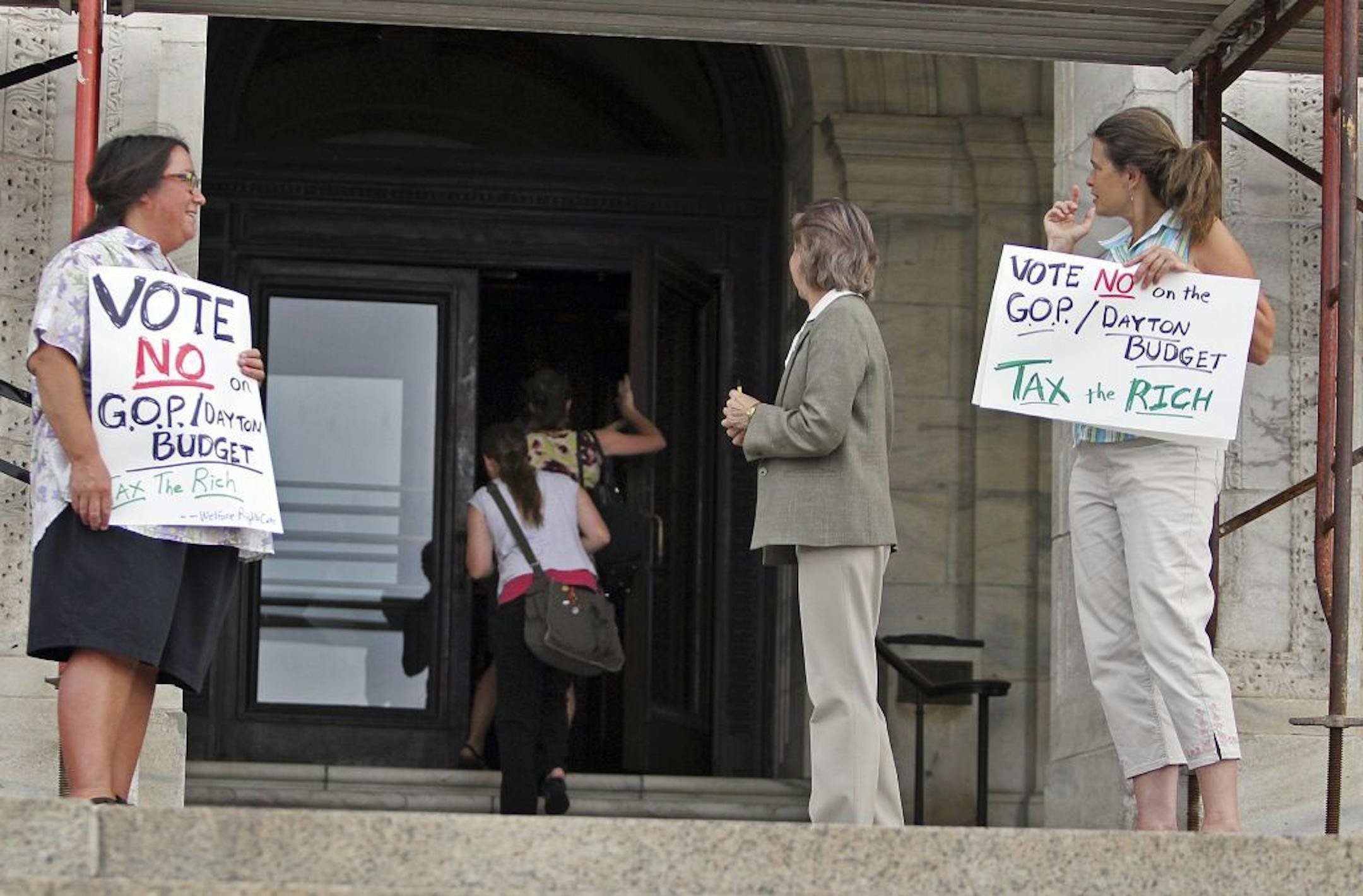 Linden Gawboy, of Minneapolis, left, and Deb Konechne, of St. Paul, represented the Welfare Rights Committee and protested Tuesday outside the reopened State Capitol. Members of the group were there to lobby against a budget agreement.