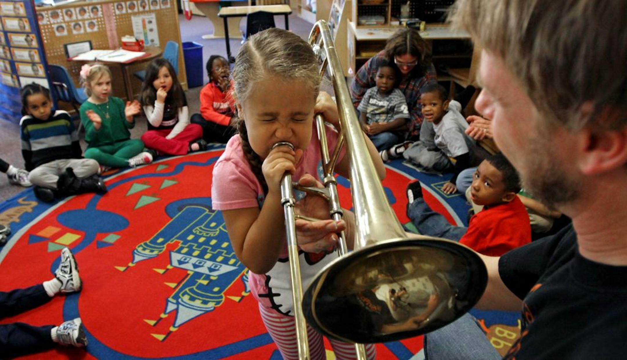 Wilder Child Development Center student Soleil Sangster tried out a trombone for MacPhail instructor Nick Johnson during a program that uses music to teach basic skills to kids.