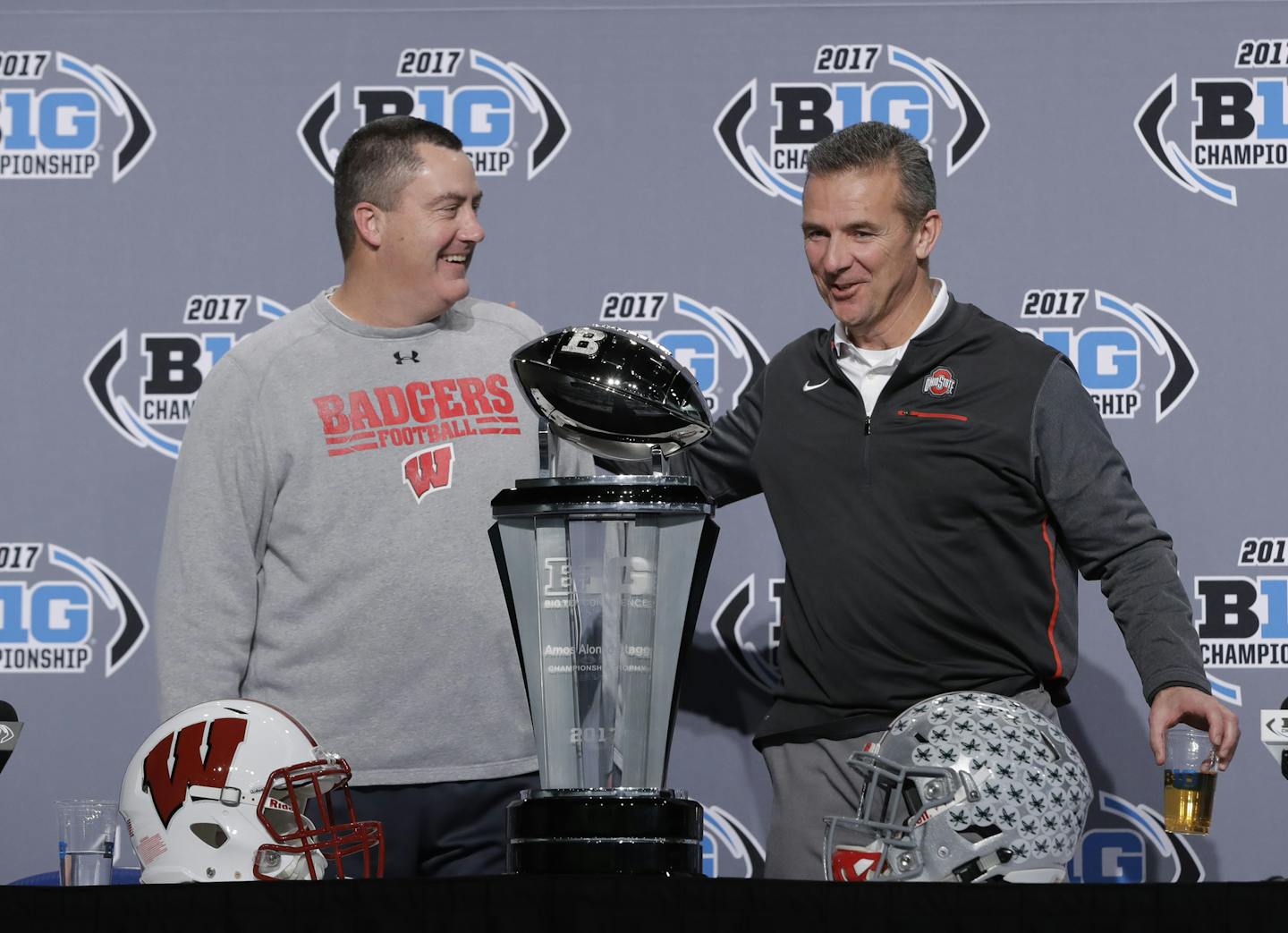 Wisconsin head coach Paul Chryst, left, talks with Ohio State head coach Urban Meyer during a news conference for the Big Ten Conference championship NCAA college football game, Friday, Dec. 1, 2017, in Indianapolis. Wisconsin will play Ohio State on Saturday for the championship. (AP Photo/Darron Cummings)