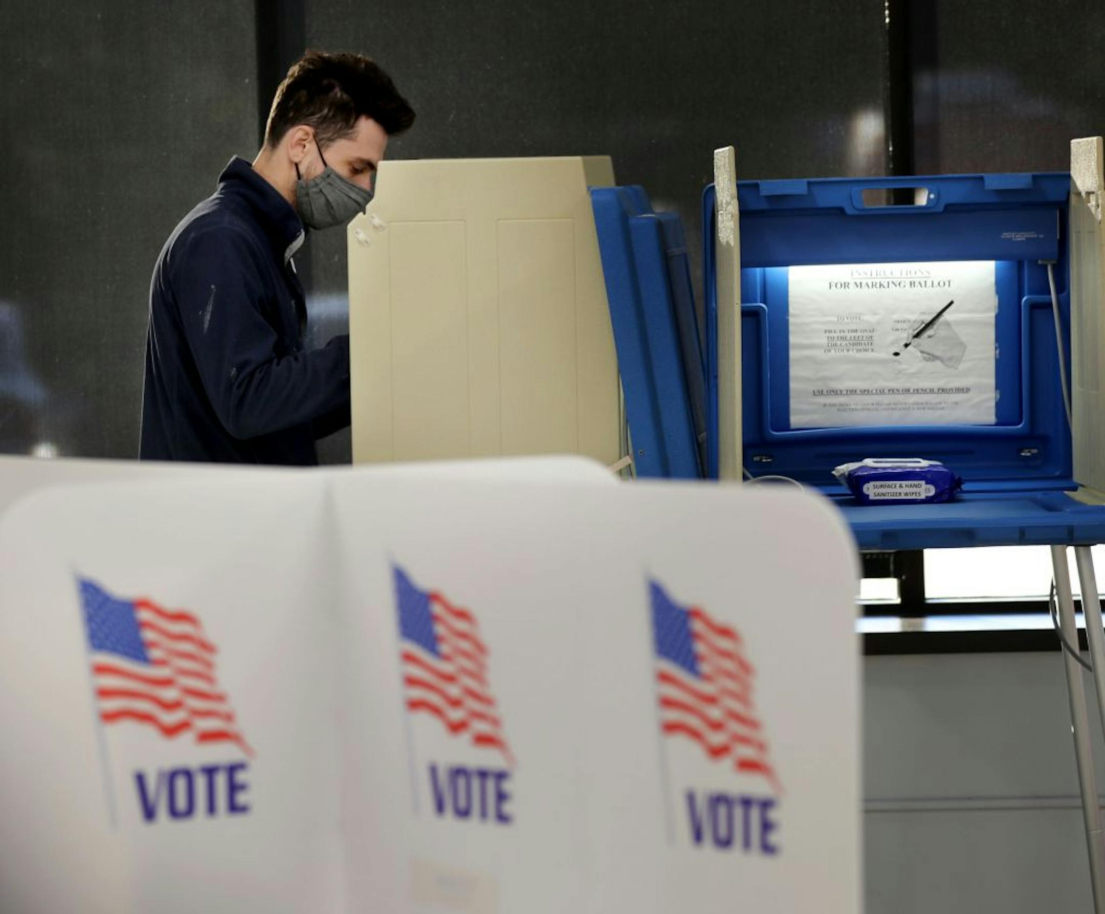 Jason Miller of Minneapolis, who was the first in line for early voting, votes at Minneapolis Elections and Voter Services Friday in Minneapolis.