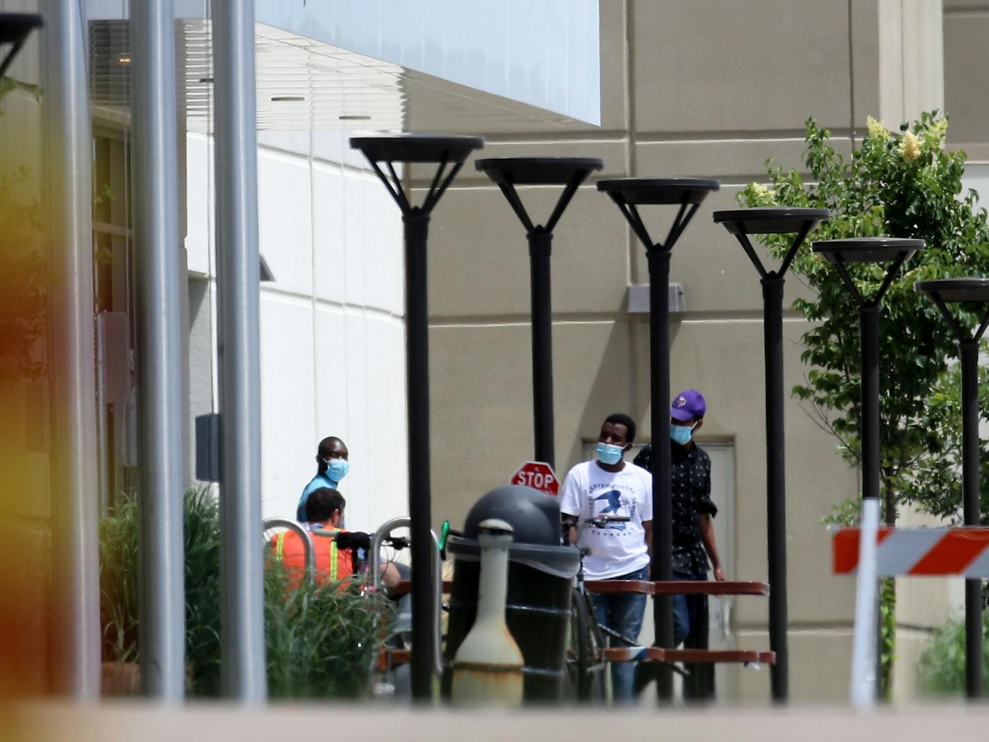 Workers are seen outside Amazon.com Inc.'s giant fulfillment center Tuesday in Shakopee, where at least 88 of its approximately 1,000 workers testing positive for the disease caused by the virus.