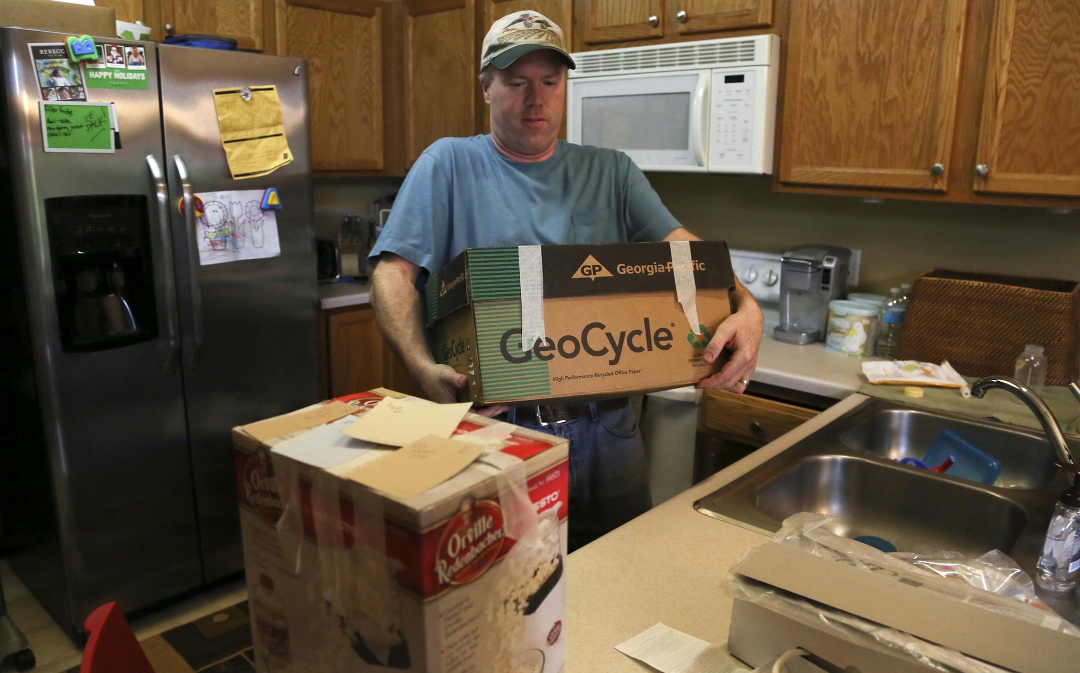 Todd and Laura Bjorgo are putting their town house on the market next week, and they're getting it ready to sell. Their painter canceled, so the couple had to scramble to find another painter at such a late date. Here, Todd carried a box of cook books from the kitchen out to the garage of their house in Cottage Grove, MN Thursday, May 30, 2013.](DAVID JOLES/STARTRIBUNE) djoles@startribune.com There are new signs that rising house prices in the Twin Cities metro are beginning to draw more would-b