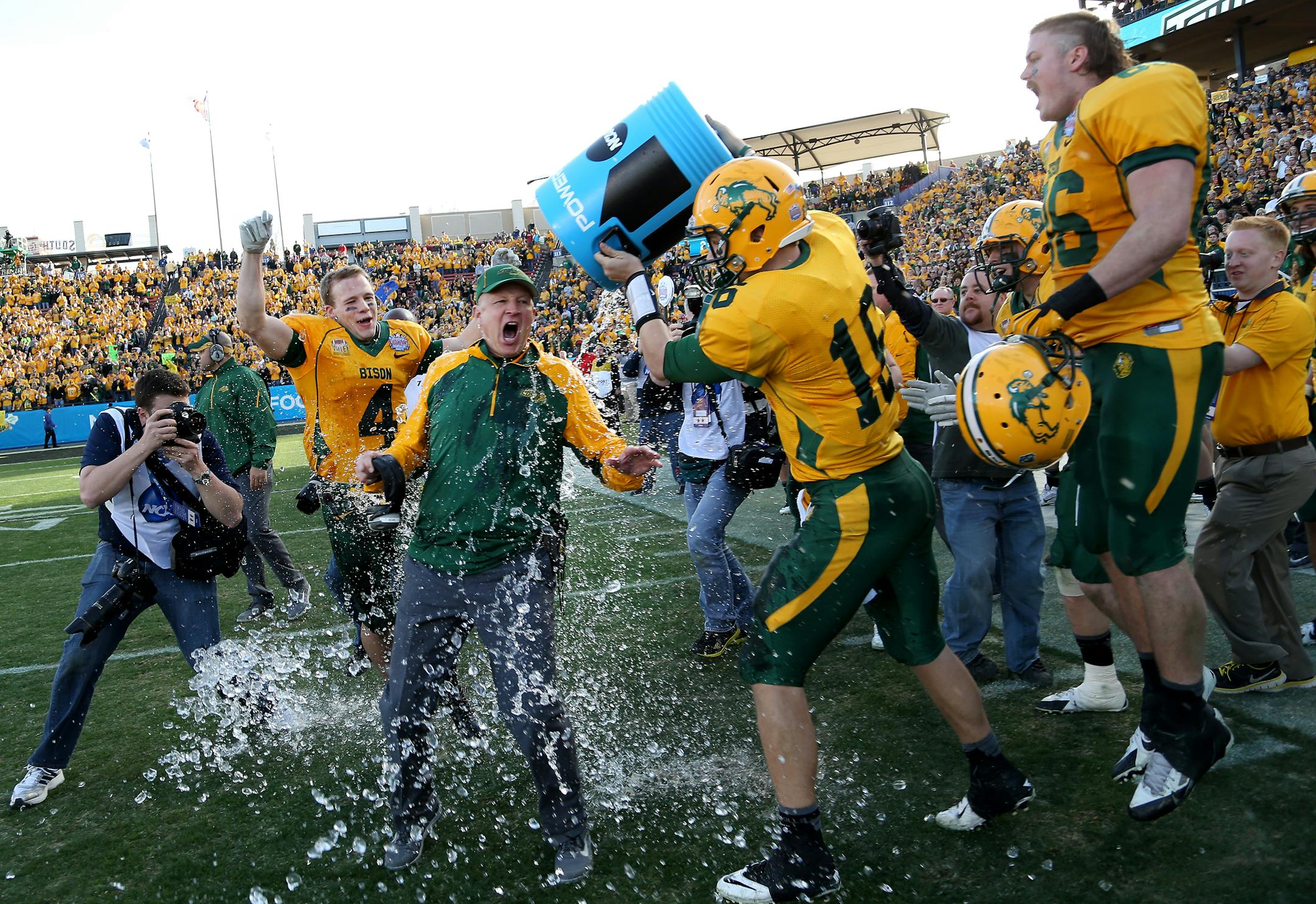 North Dakota State coach Craig Bohl had the water cooler dumped on him by quarterback Brock Jensen (16) late in the second half FCS title football game against Towson on Saturday in Frisco, Texas. North Dakota State won 35-7.