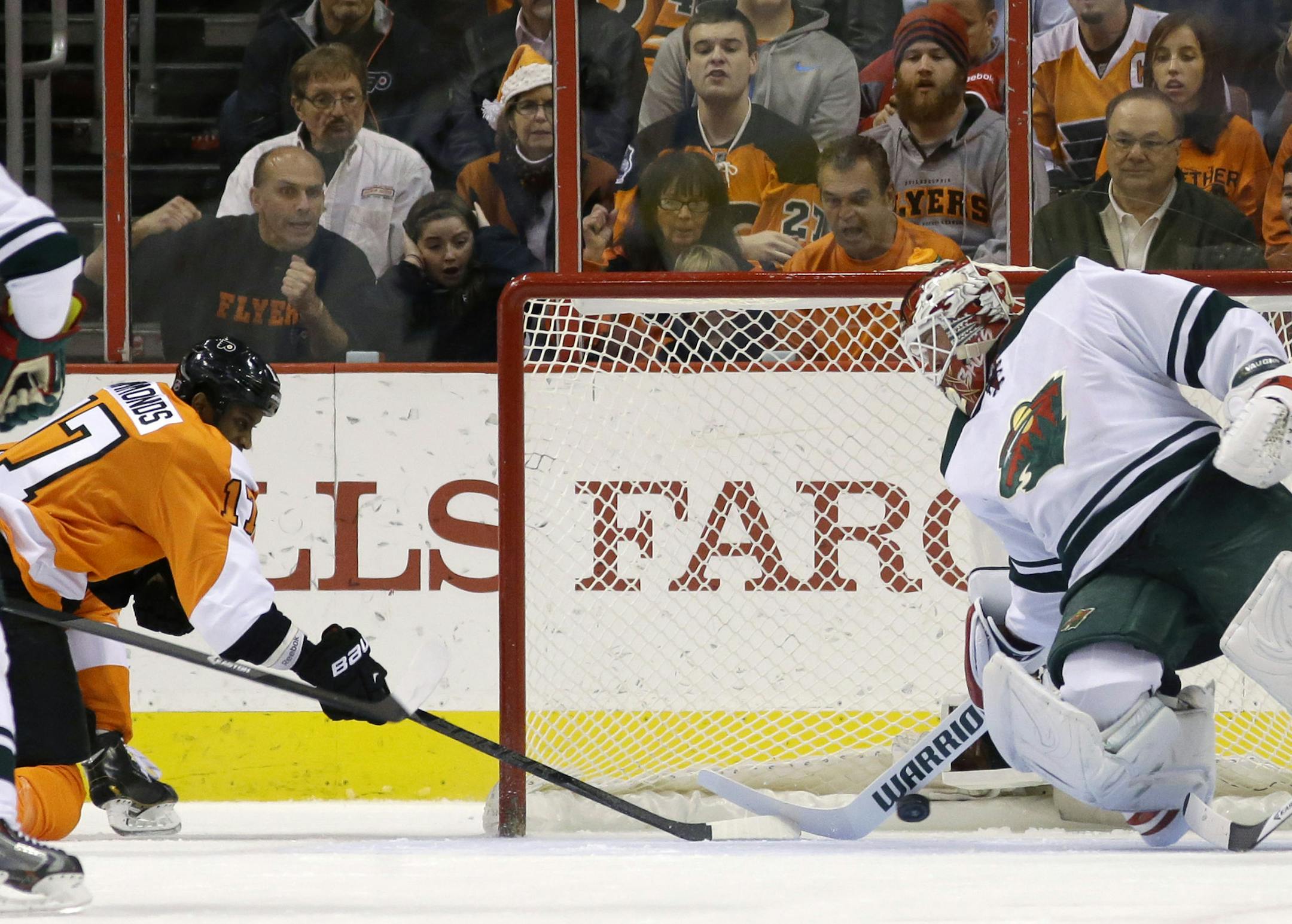 Philadelphia Flyers' Wayne Simmonds, left, scores a goal past Minnesota Wild's Niklas Backstrom, of Finland, during the first period of an NHL hockey game, Monday, Dec. 23, 2013, in Philadelphia. (AP Photo/Matt Slocum)