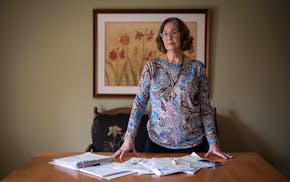 Vickie Schaefer poses for a portrait with paperwork and notes related to her mother’s care at her home in Plymouth.