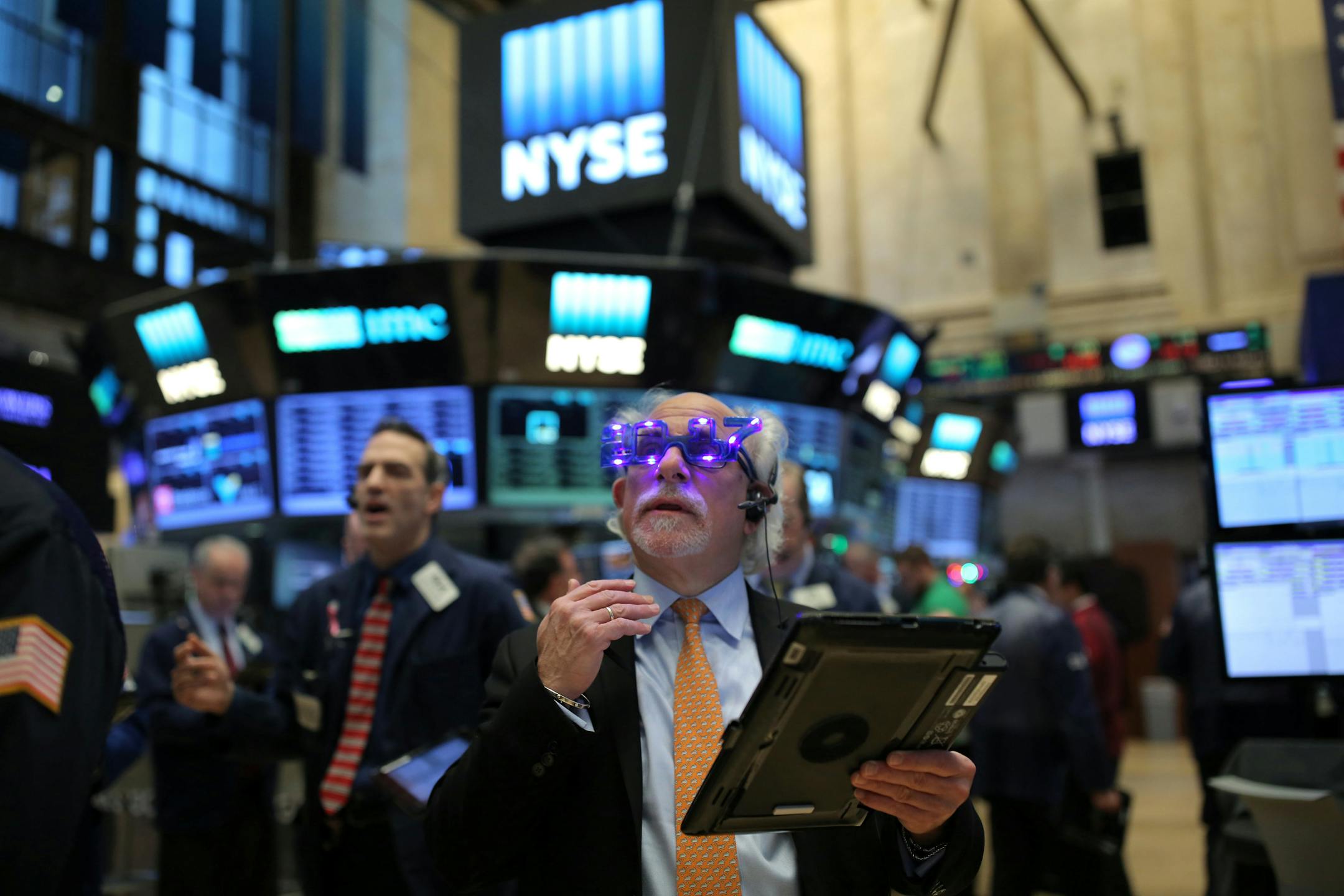 A trader wears glasses that say "2017" ahead of the new year on the floor of the New York Stock Exchange (NYSE) in Manhattan, New York City, U.S., December 30, 2016. REUTERS/Stephen Yang