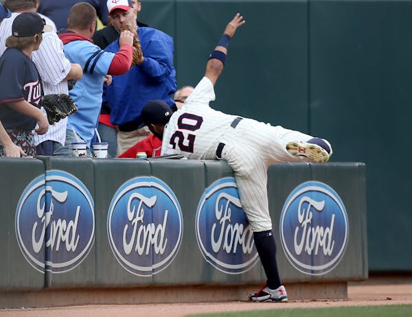 Twins Eddie Rosario tried to grab a foul play in the stands in the first inning