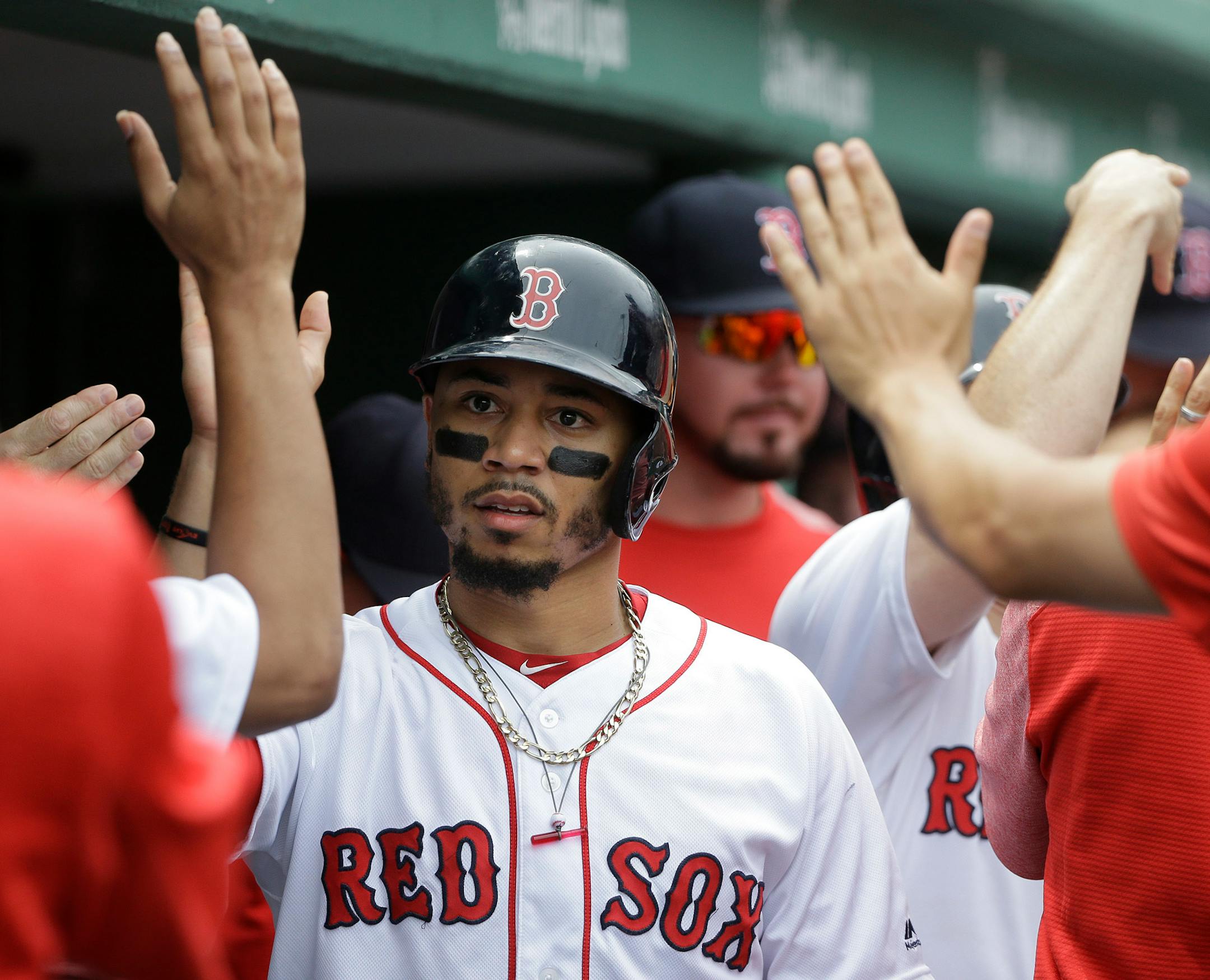 Boston Red Sox's Mookie Betts is welcomed to the dugout after scoring on an RBI-double by J.D. Martinez off a pitch by Minnesota Twins' Jose Berrios in the second inning of a baseball game, Sunday, July 29, 2018, in Boston. (AP Photo/Steven Senne)
