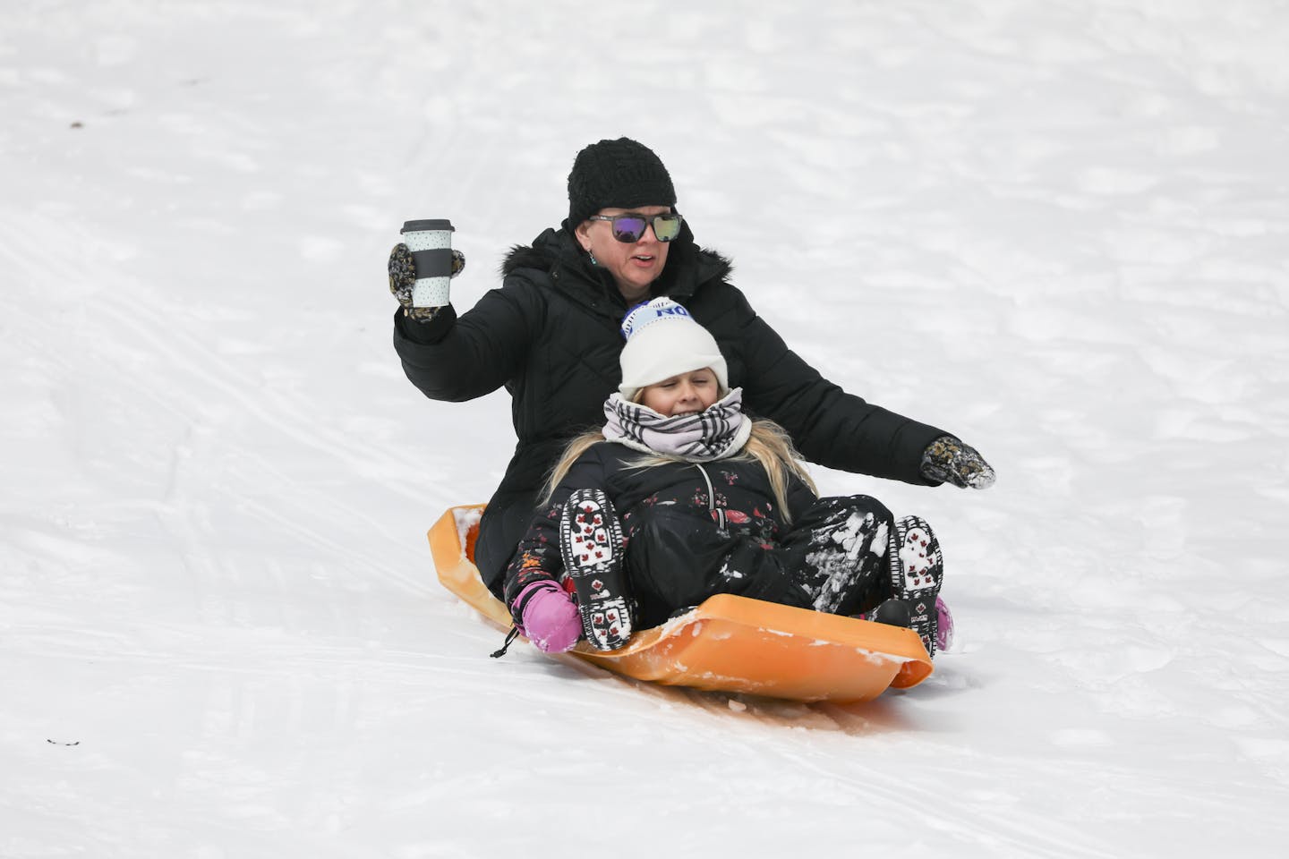 Anne-Marie Fischer held on to her coffee as she rode a sled down a hill at Pearl Park with her daughter Holiday Fischer, 10, on a snow day on Monday, April 16, 2018 in Minneapolis, Minn. ] RENEE JONES SCHNEIDER &#x2022; renee.jones@startribune.com