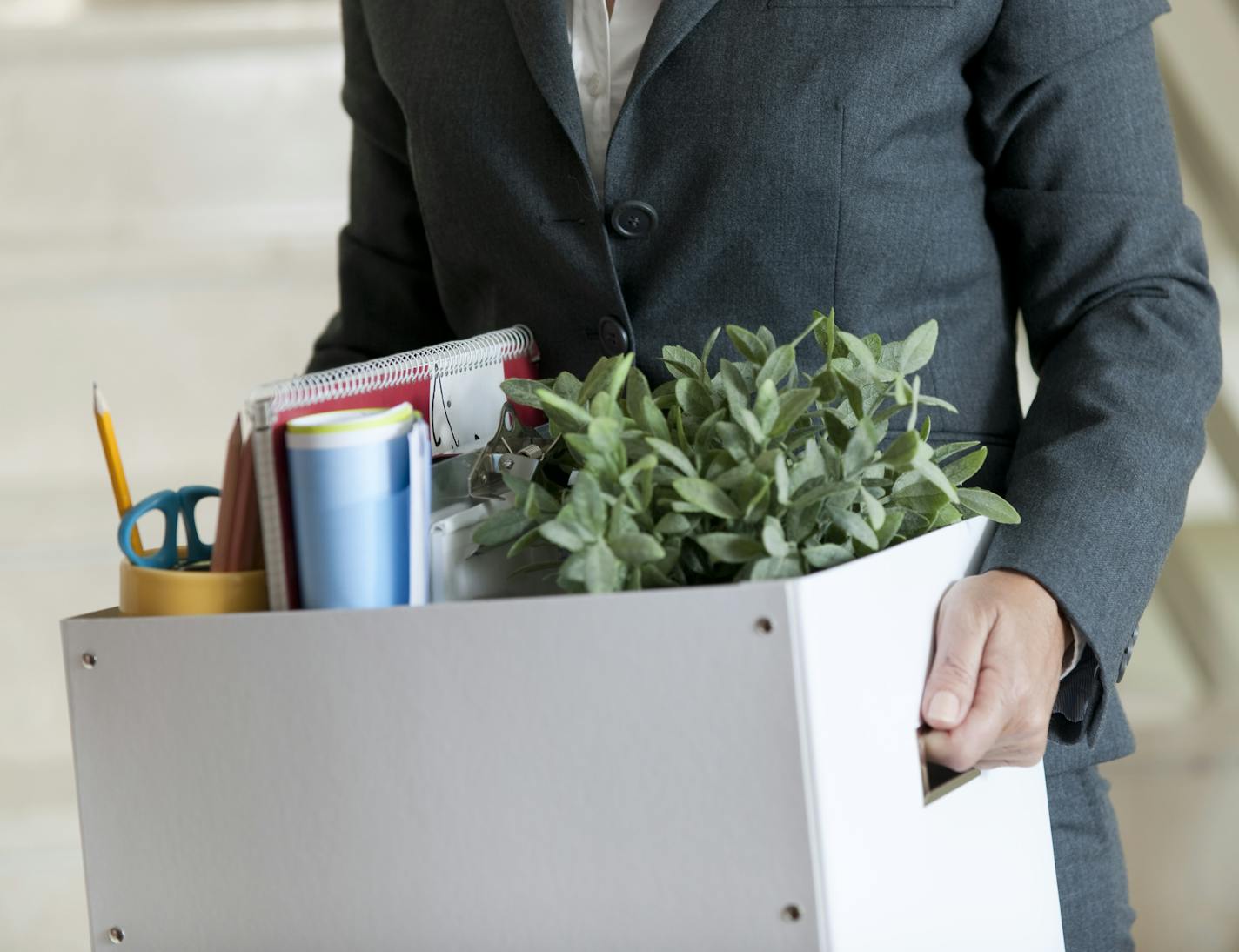 Mid Section View of a Businesswoman Holding a Cardboard Box Containing a Large Group of Objects