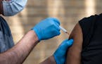 In this May 27, 2021, file photo, National Guard Spc. Noah Vulpi administers the COVID-19 vaccine to Ira Young Jr. during a vaccination clinic held by