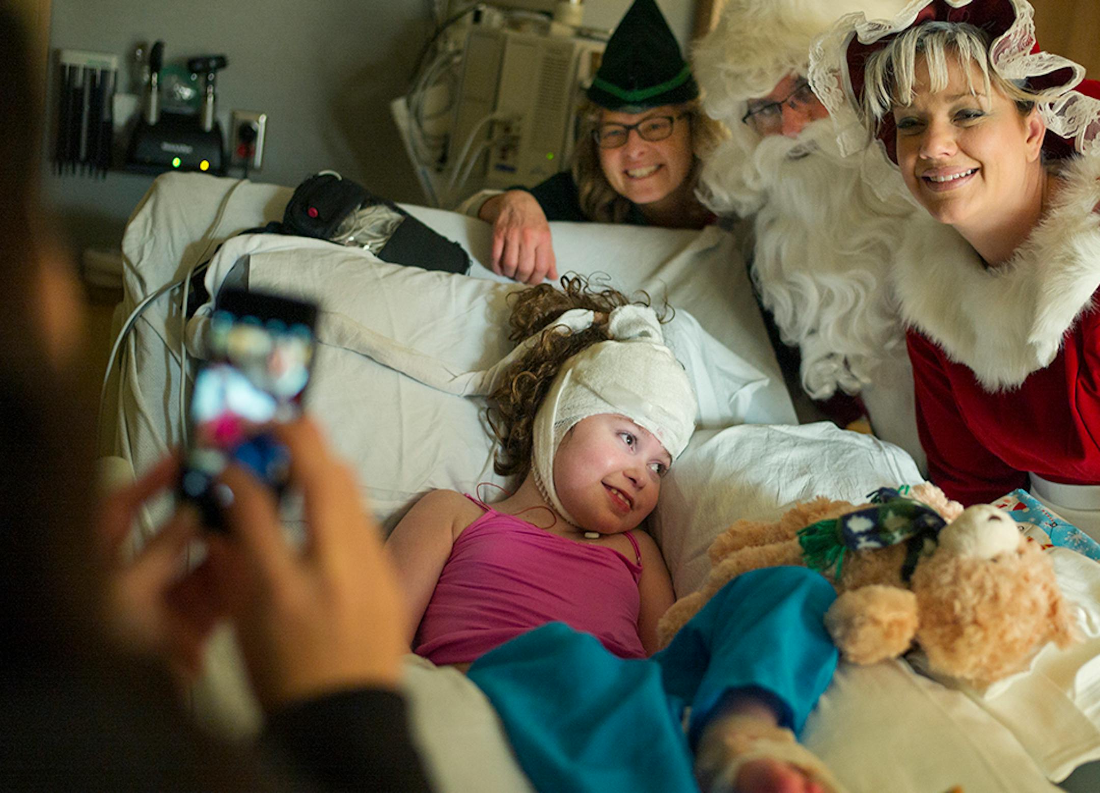 At Gillette Children's Specialty Healthcare, Sgt. Santa Claus a.k.a. Todd Feroni, his elf helper officer Lucia Wroblewski, and Mrs. Claus a.k.a. officer Amy Rahlf visited Emily Kargel, 9.5, who just underwent a treatment for epilepsy. Mom Kristy took a picture.